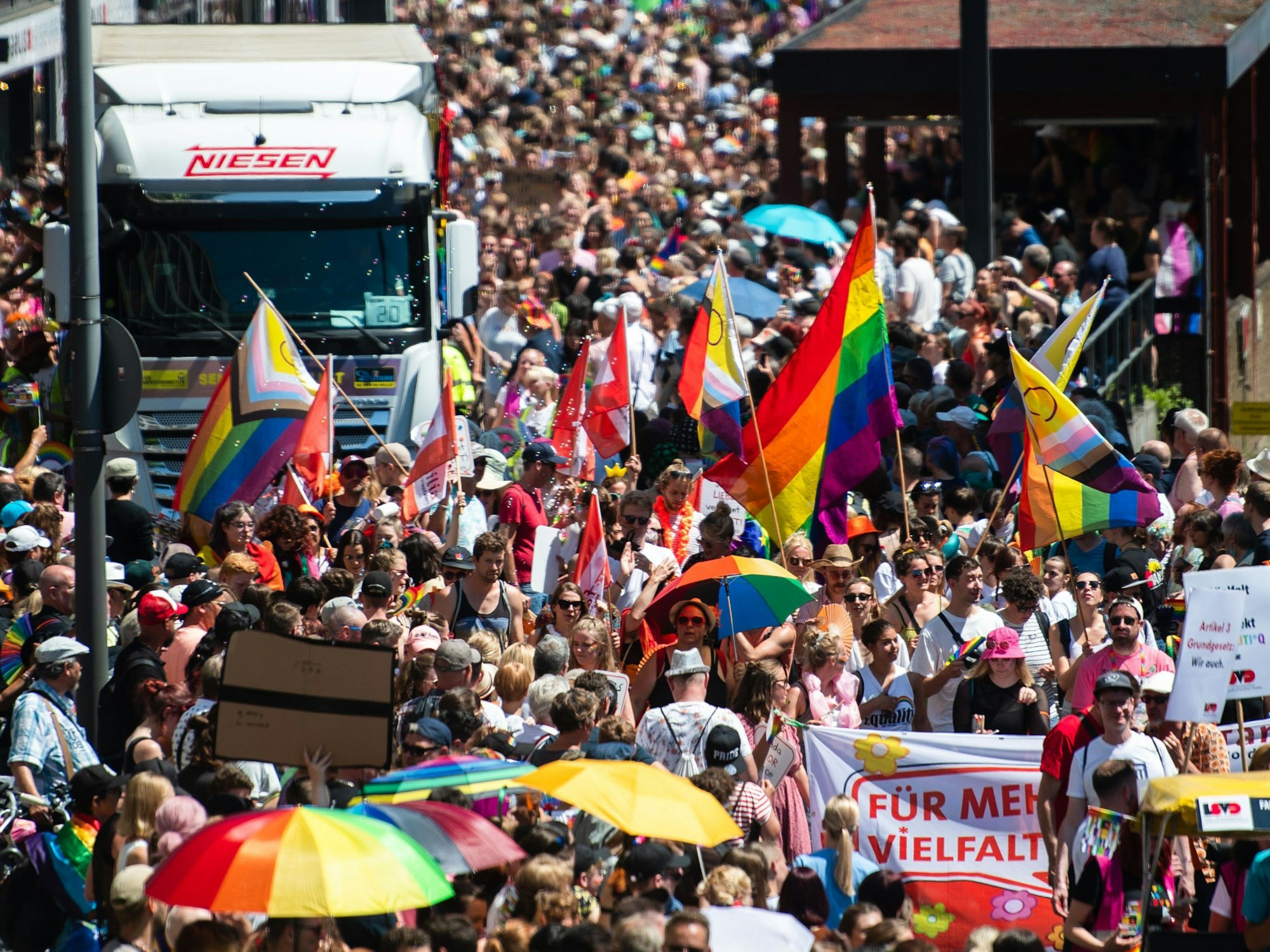 Teilnehmer und Teilnehmerinnen einer Parade zum Christopher Street Day (CSD) ziehen in Köln durch die Stadt.