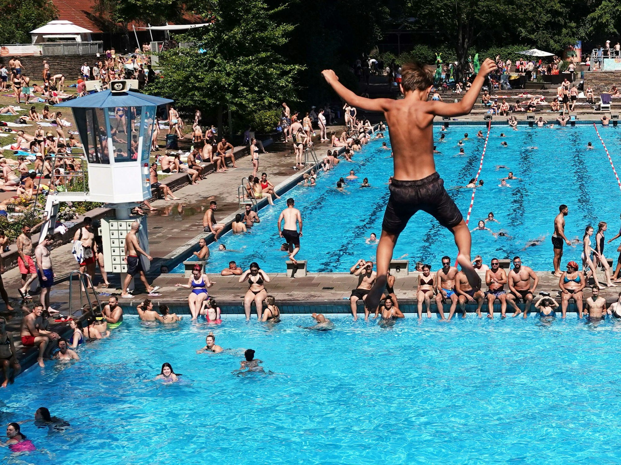 Ein Junge springt am 20. Juli 2022 vom Fünf-Meter-Turm des Kaifu-Freibads in Hamburg.