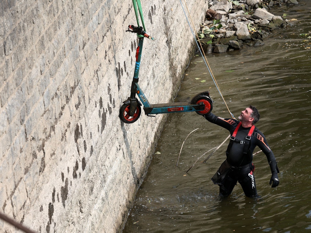 Christian Stock von Krake hat einen E-Scooter aus dem Rhein geborgen, der an einem Seil nach oben gezogen wird.