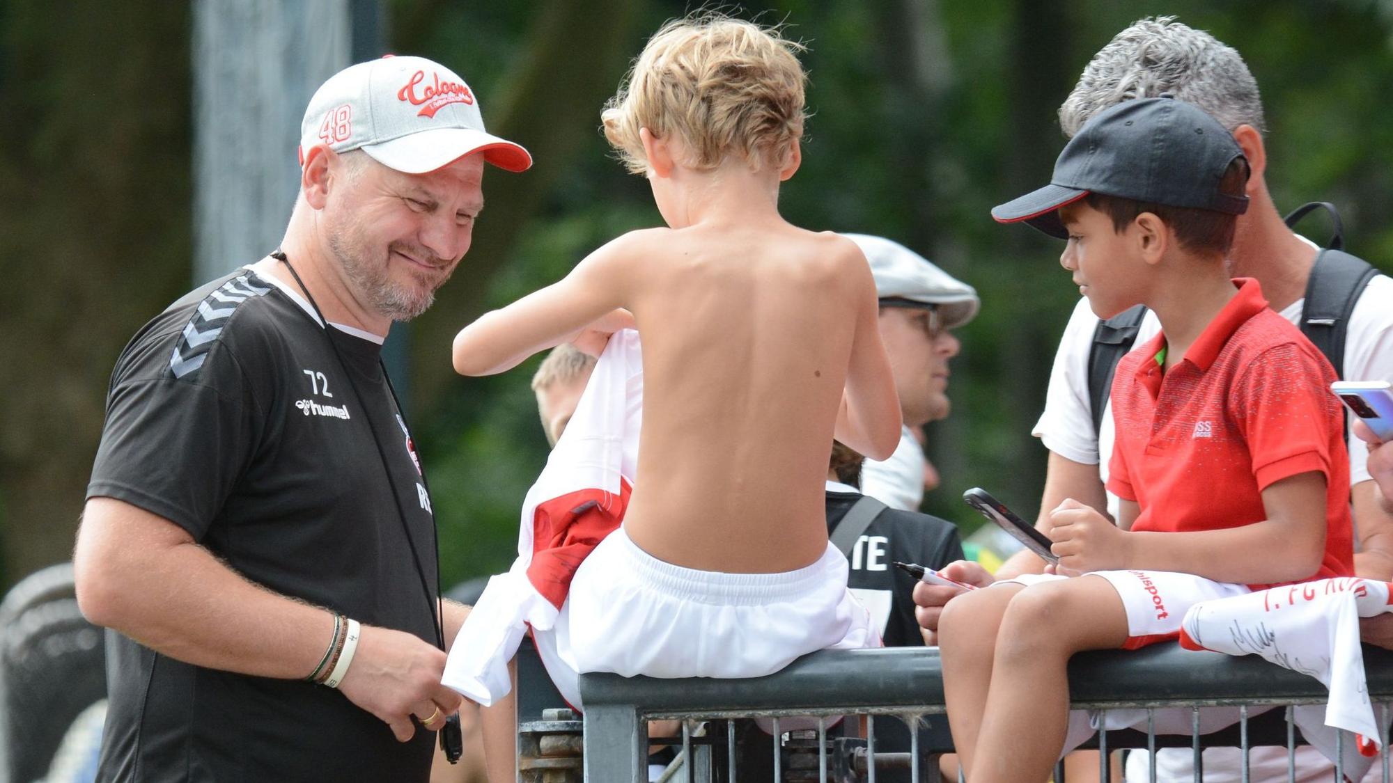 Coach Steffen Baumgart unterhält sich mit jungen Fans beim Training
