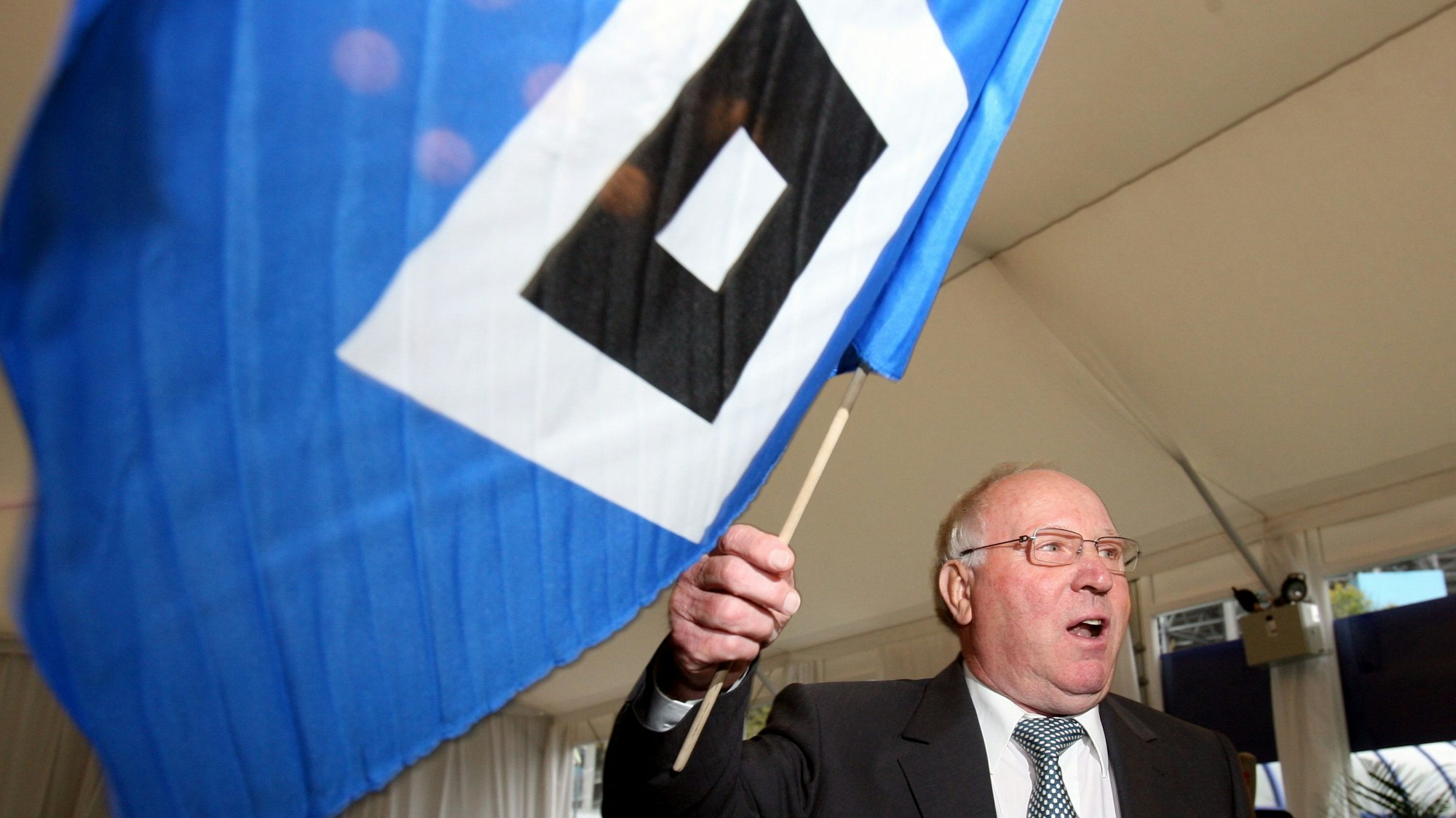 Der Ehrenspielführer der deutschen Fußball-Nationalmannschaft und ehemalige Spieler des Hamburger SV, Uwe Seeler, schwenkt zu Beginn seiner Feier zum 70. Geburtstag in Hamburg die Fahne vom HSV.