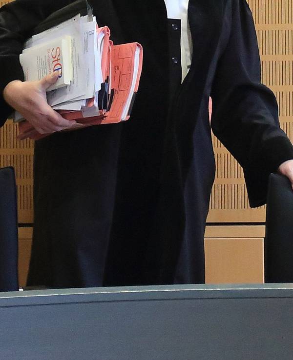 Ein Richter rückt sich zum Auftakt eines Mordprozesses in einem Verhandlungssaal seinen Stuhl zurecht, wie dieses undatierte Symbolbild zeigt.