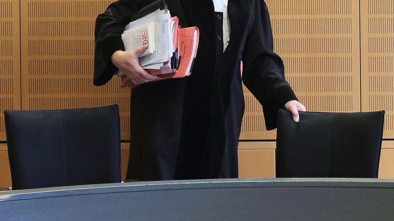 Ein Richter rückt sich zum Auftakt eines Mordprozesses in einem Verhandlungssaal seinen Stuhl zurecht, wie dieses undatierte Symbolbild zeigt.