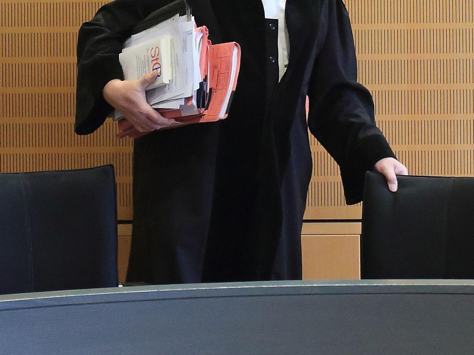 Ein Richter rückt sich zum Auftakt eines Mordprozesses in einem Verhandlungssaal seinen Stuhl zurecht, wie dieses undatierte Symbolbild zeigt.