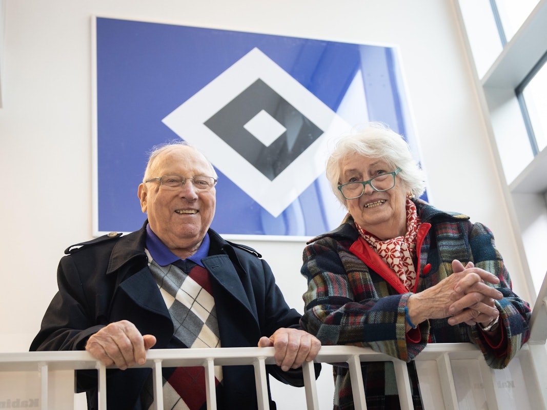Uwe Seeler und seine Frau Ilka vor dem Logo des Hamburger SV