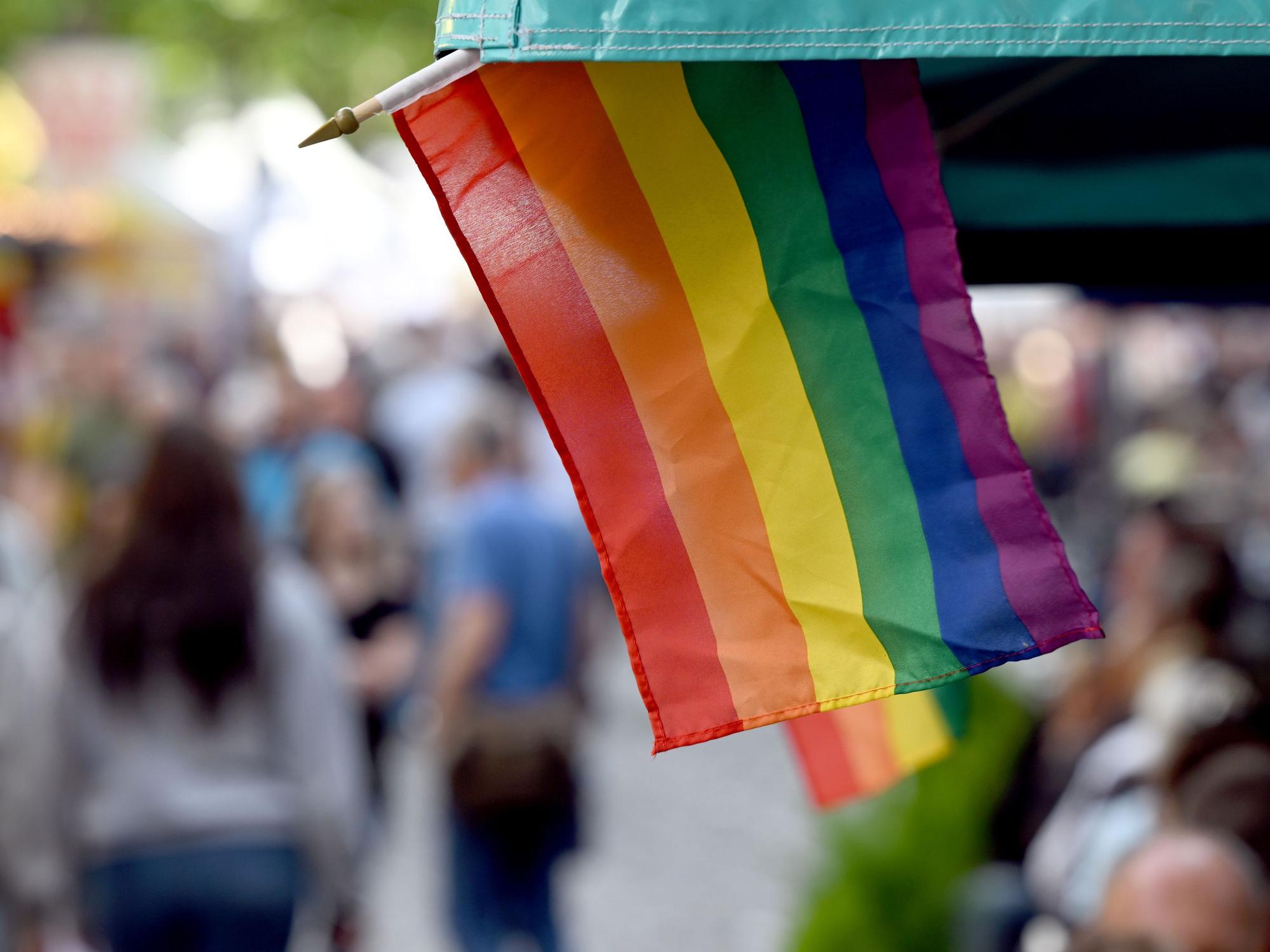 Regenbogenflaggen sind an einem Marktstand angebracht.