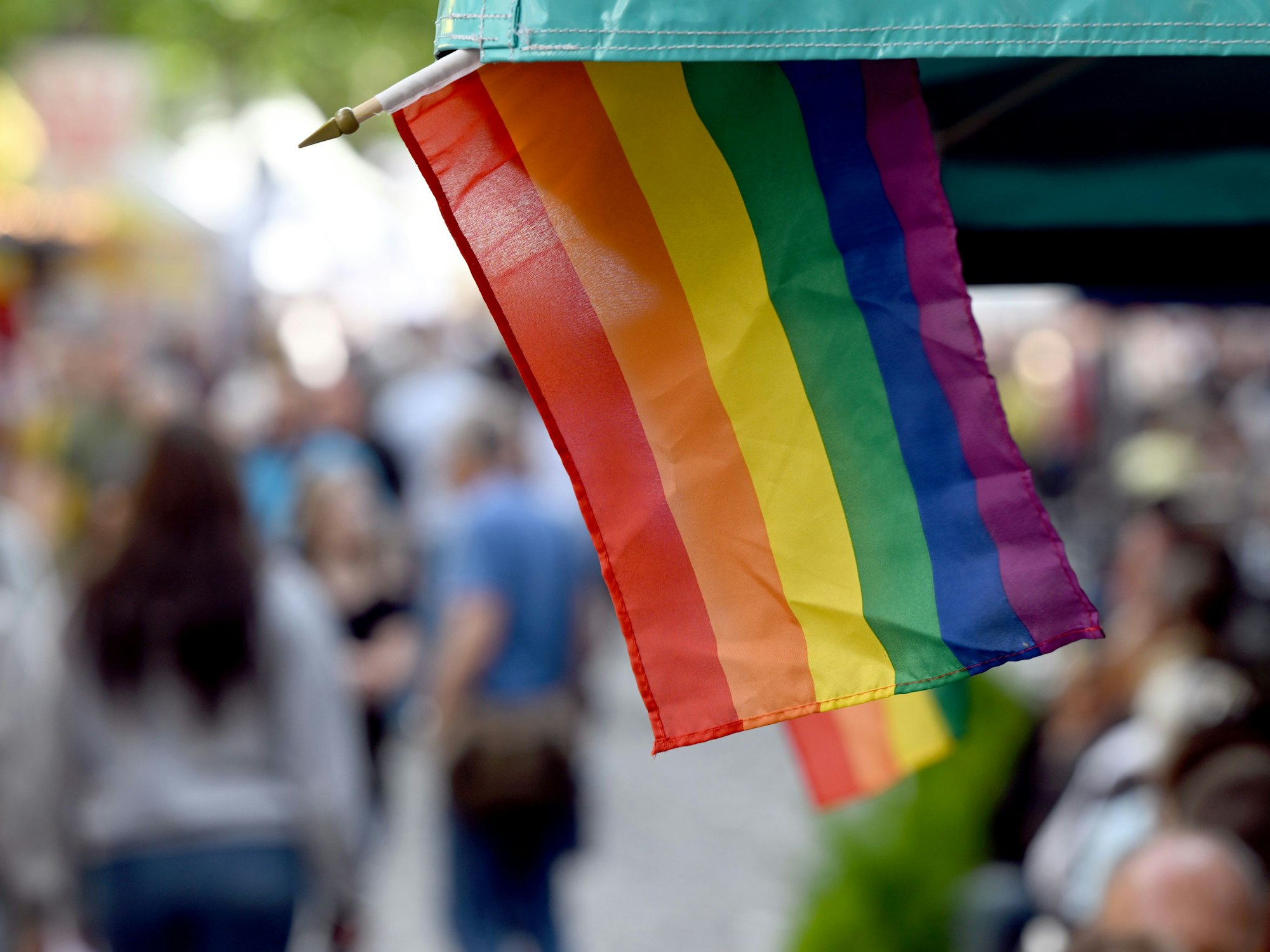 Regenbogenflaggen sind an einem Marktstand angebracht.