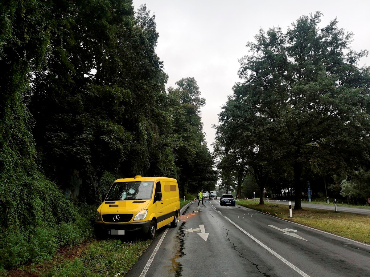 Ein Geldtransporter steht neben einer Straße, auf der ein Polizist Spuren sichert.