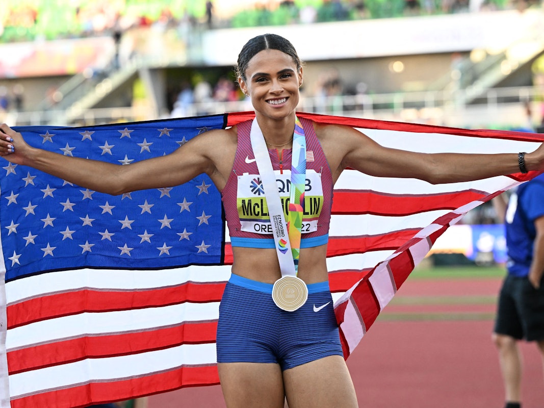 Sydney Mclaughlin posiet mit der US-Flagge und ihrer Goldmedaille.