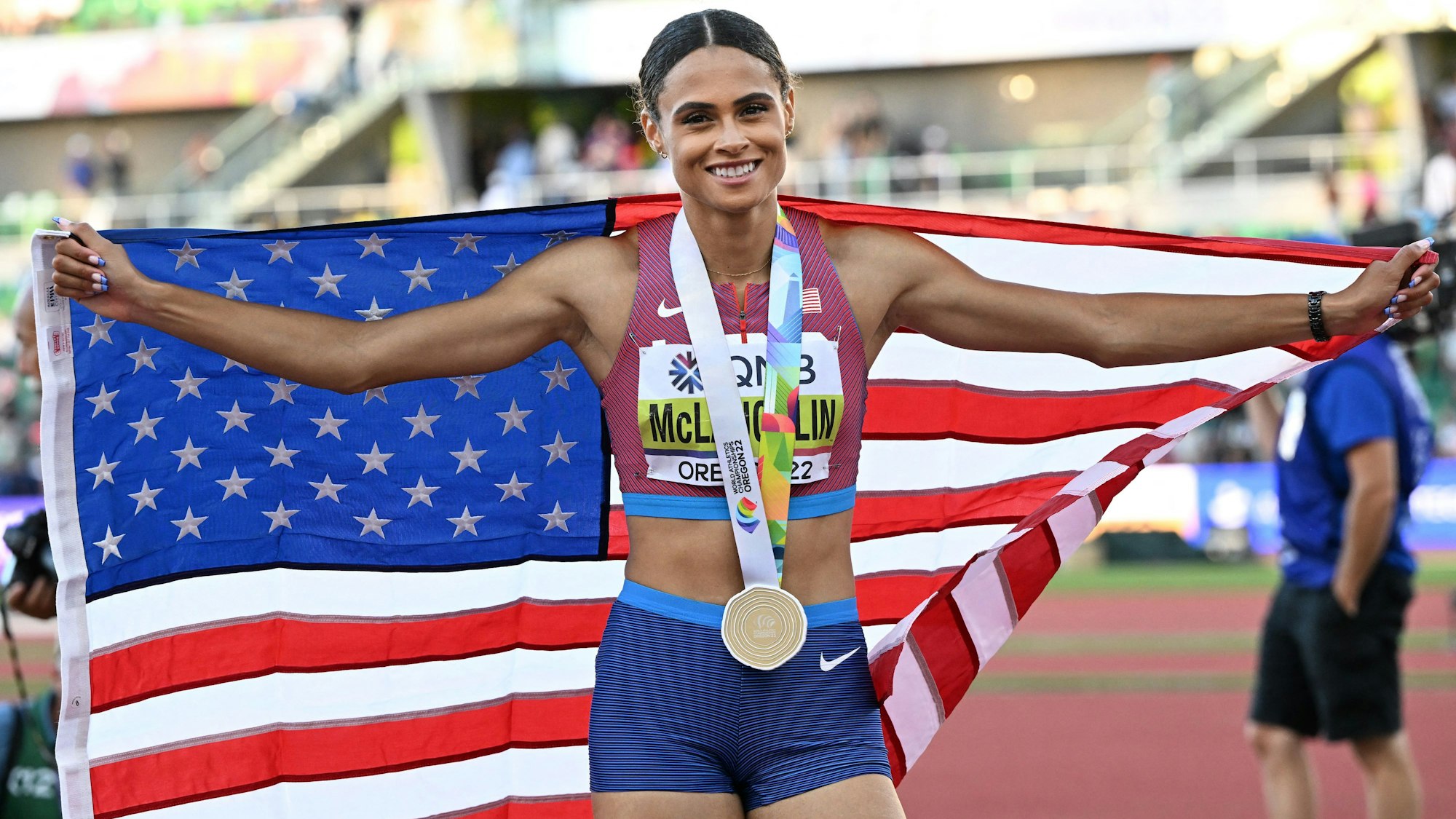 Sydney Mclaughlin posiet mit der US-Flagge und ihrer Goldmedaille.