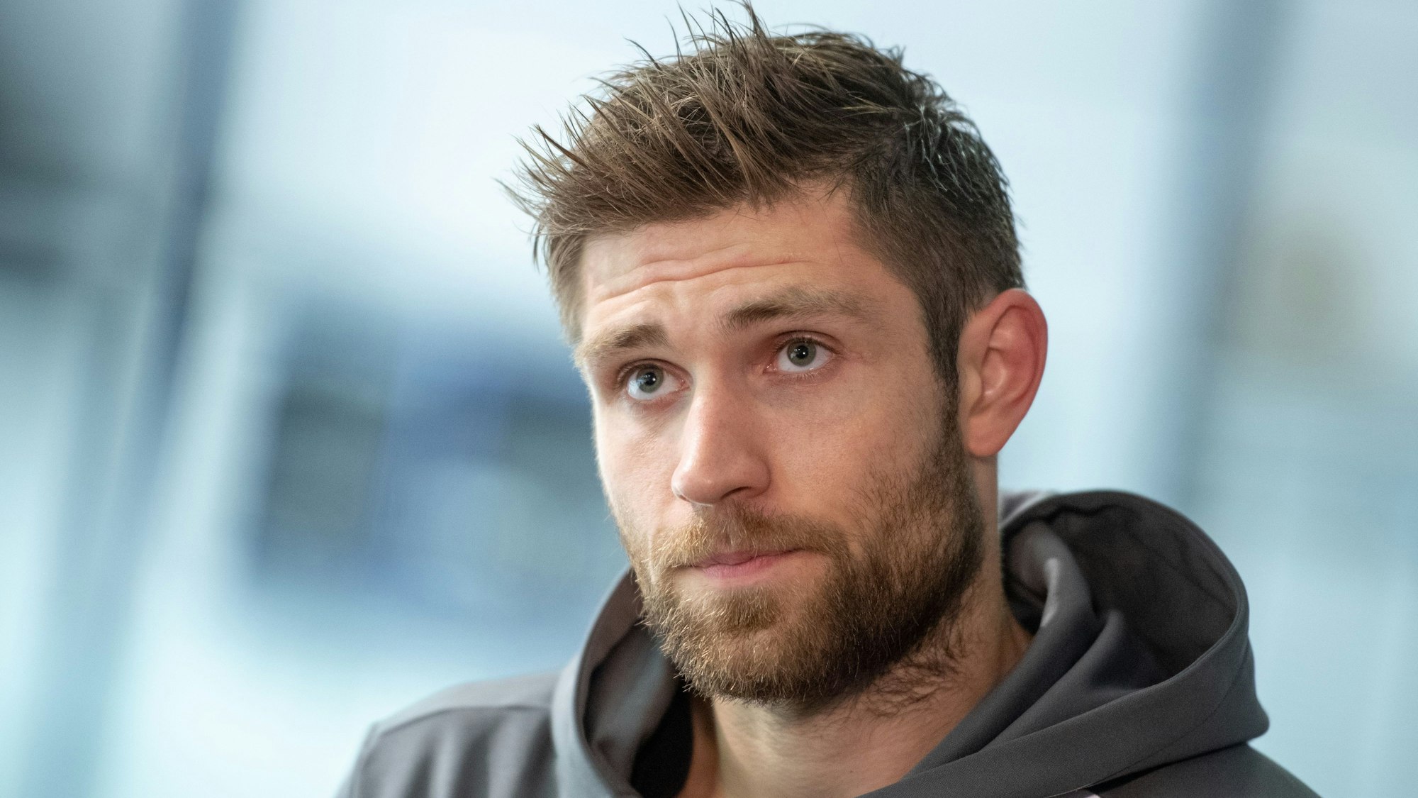 Eishockeyspieler Leon Draisaitl blickt während eines Pressestatements in die Runde.