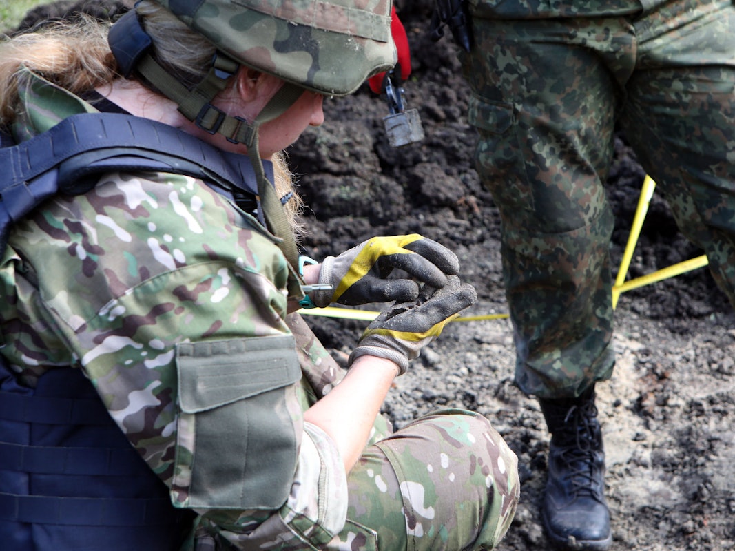 Eine Polizistin sucht nach den Splittern einer russischen Granate, die auf dem Gelände einer akademischen Einrichtung im Nordosten der Ukraine eingeschlagen ist.