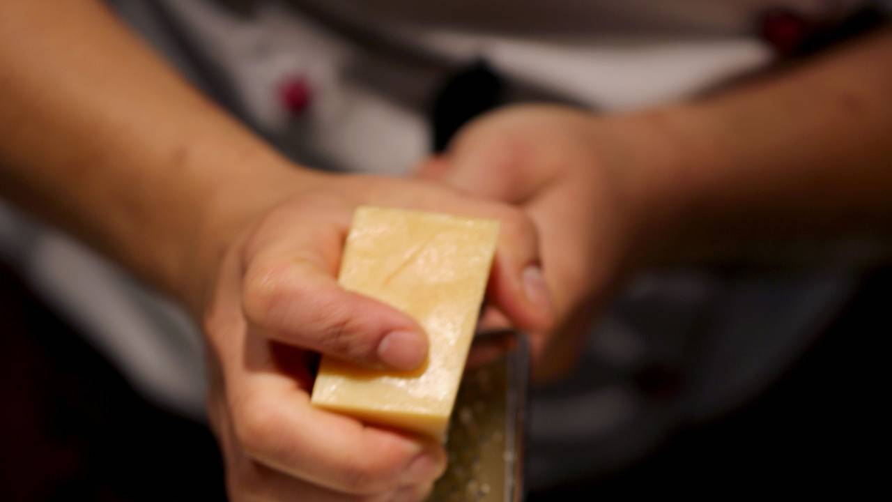 Ein Köchin reibt in einer Filiale der Restaurantkette Vapiano Parmesan auf ein Pasta-Gericht.
