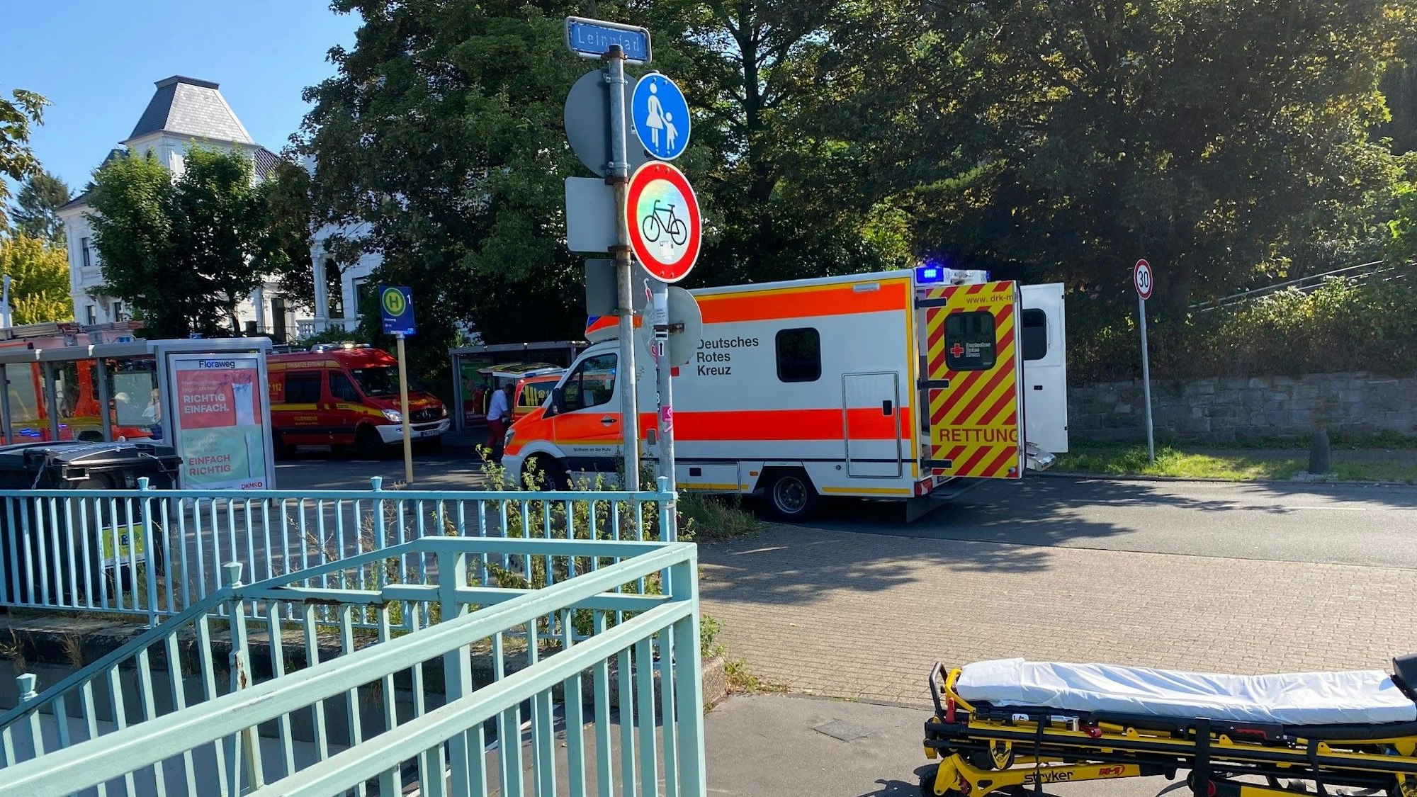 Ein Rettungswagen mit offener Tür steht auf der Straße, ein paar Meter davor befindet sich eine Trage auf dem Boden.