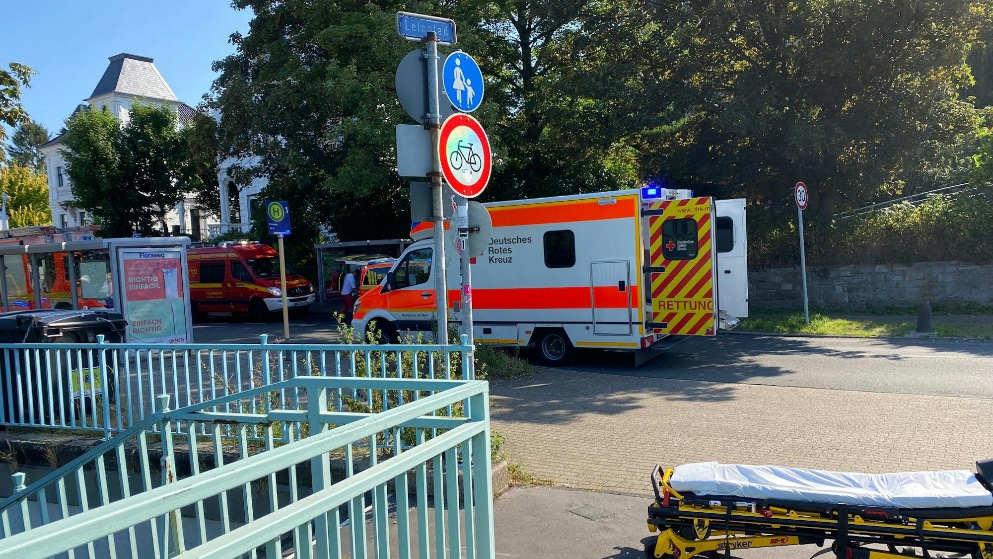 Ein Rettungswagen mit offener Tür steht auf der Straße, ein paar Meter davor befindet sich eine Trage auf dem Boden.
