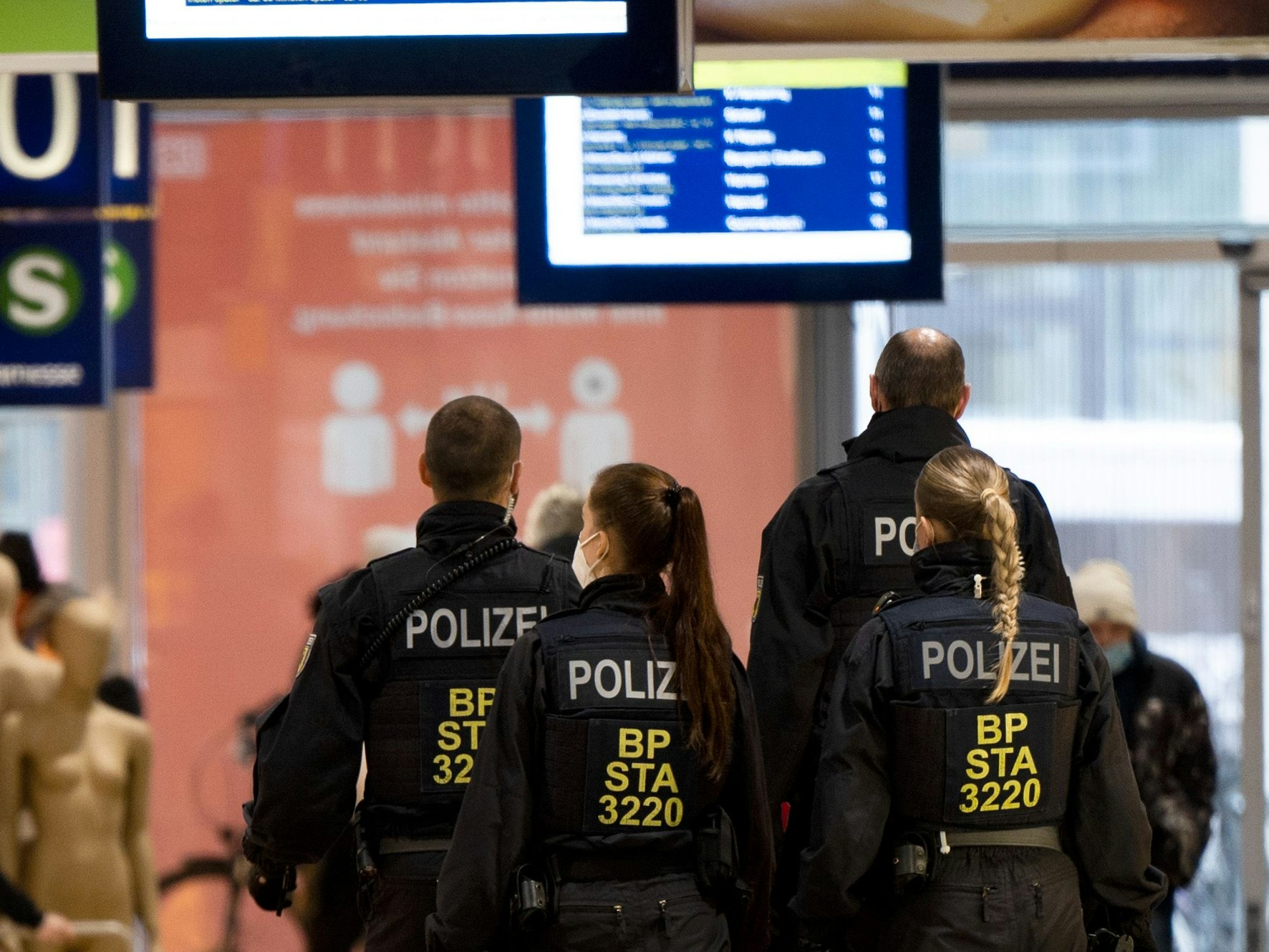 Polizisten gehen in einer Gruppe durch den Bahnhof.