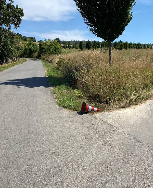 Eine Pylone liegt an einem Weg und soll der Feuerwehr die Richtung weisen.