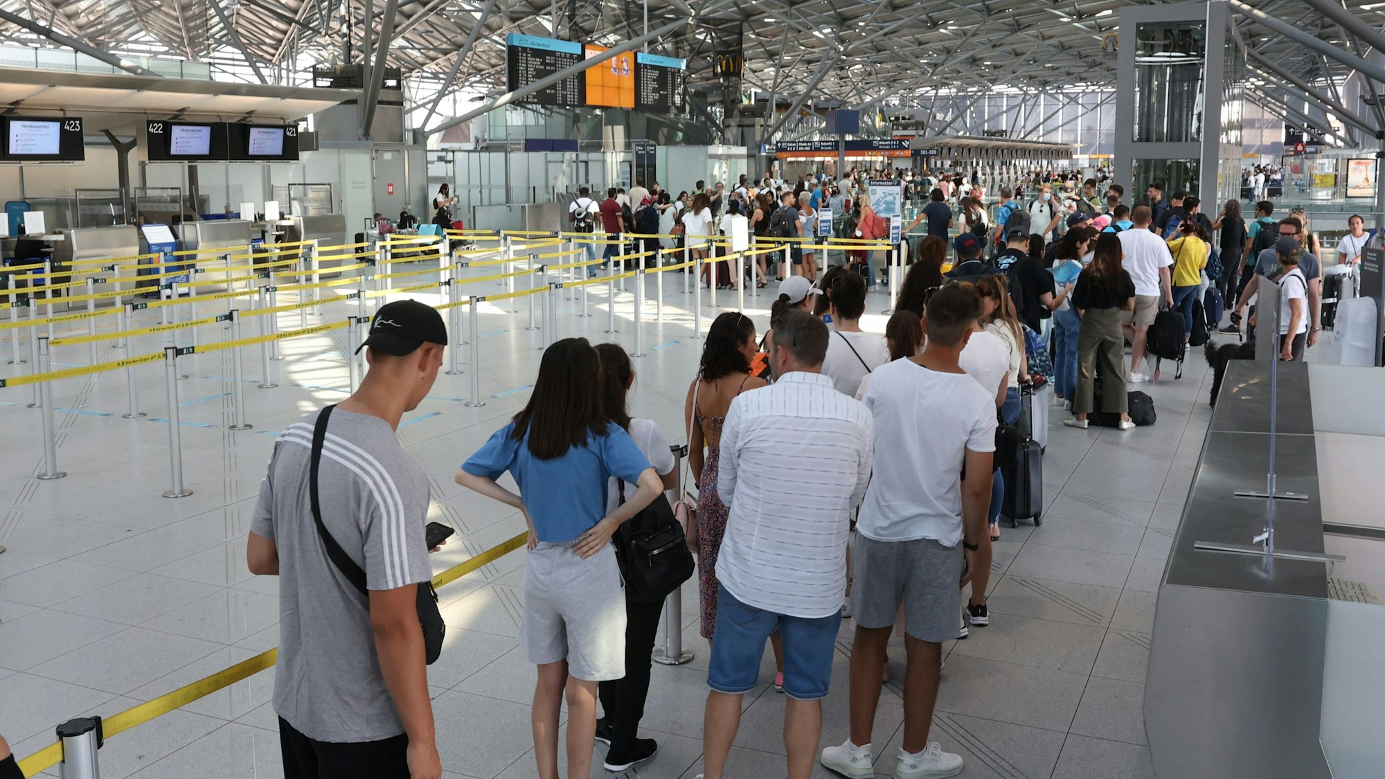 Lange Schlange vor dem Check-In bis ans Ende von Terminal 2 am Flughafen Köln/Bonn am 24. Juli 2022.