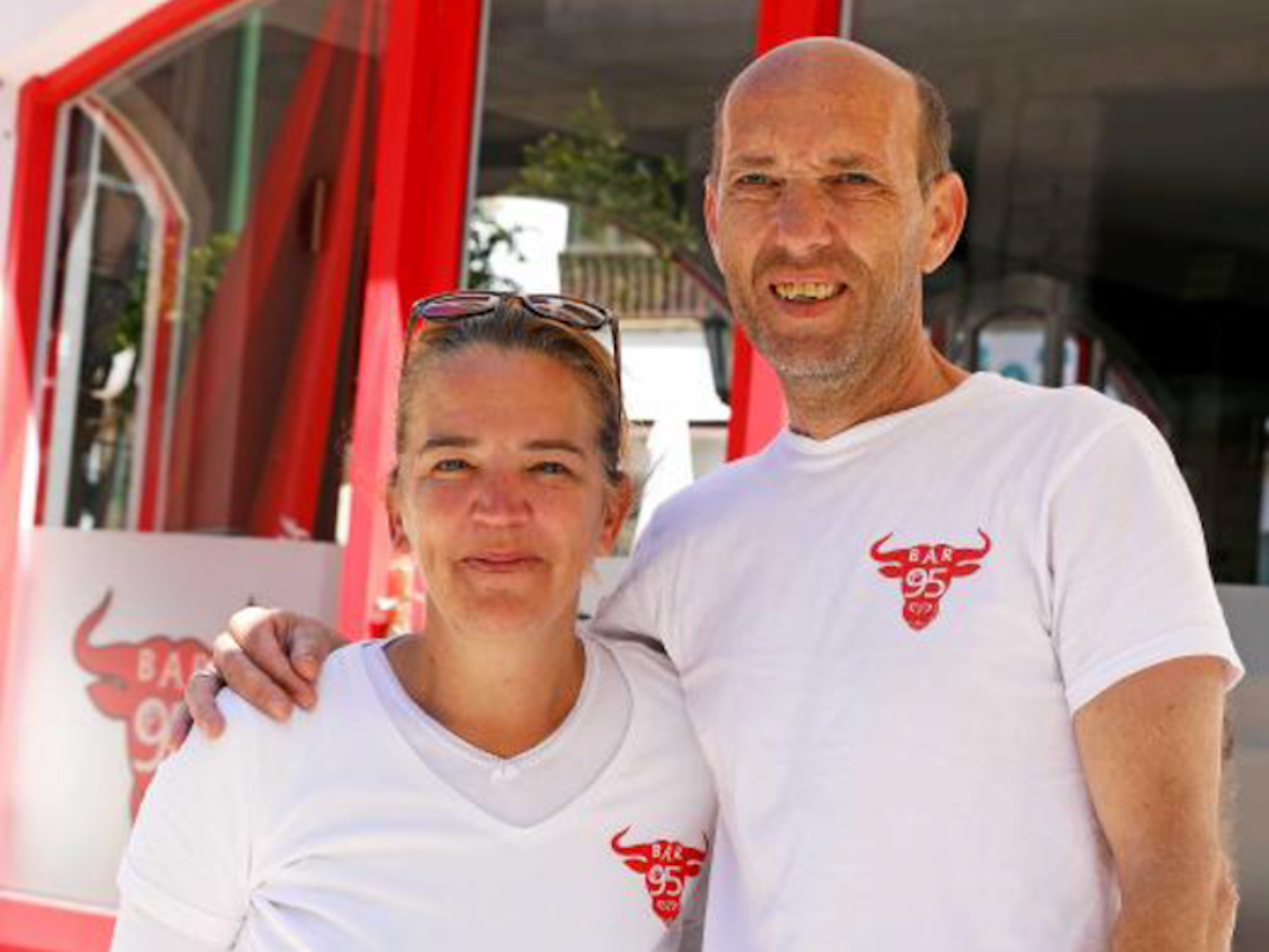 Michaela und Frank Wienhusen vor ihrem Restaurant „Bar 95“, sie lächeln in die Kamera.