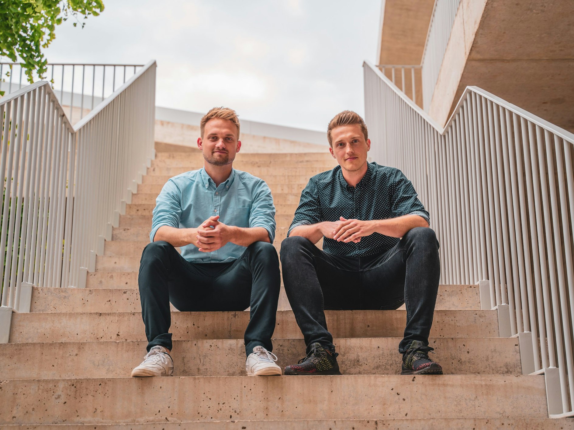 Die NeoTaste-Gründer Tobias Düser und Hendrik Sander sitzen auf einer Treppe.