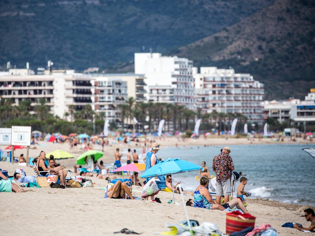 Urlauber am Strand der Costa Brava in Katalonien.