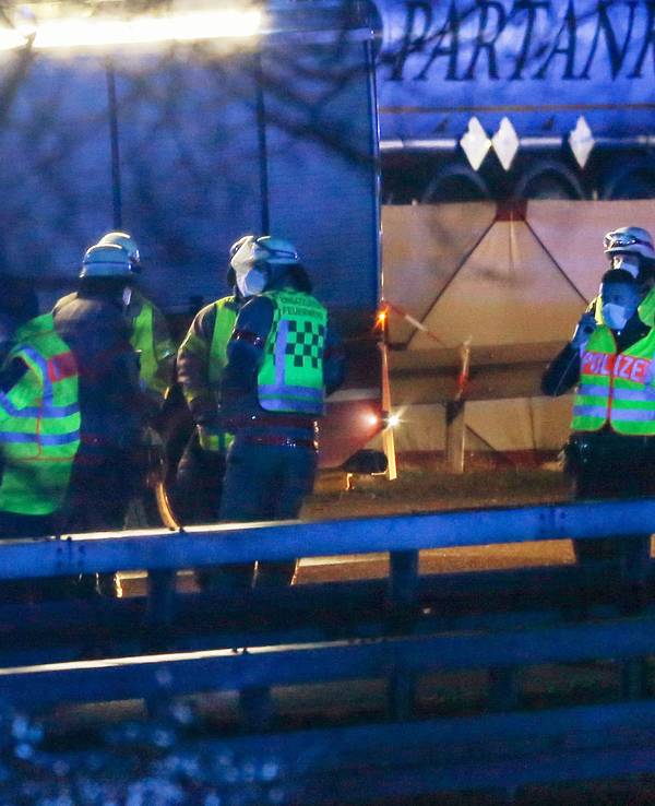 Feuerwehrleute und Polizisten stehen an der Autobahn 44 bei Aachen. Auf einem Rastplatz an der A44 ist ein 22-jähriger Belgier bei einem Unfall ums Leben gekommen.