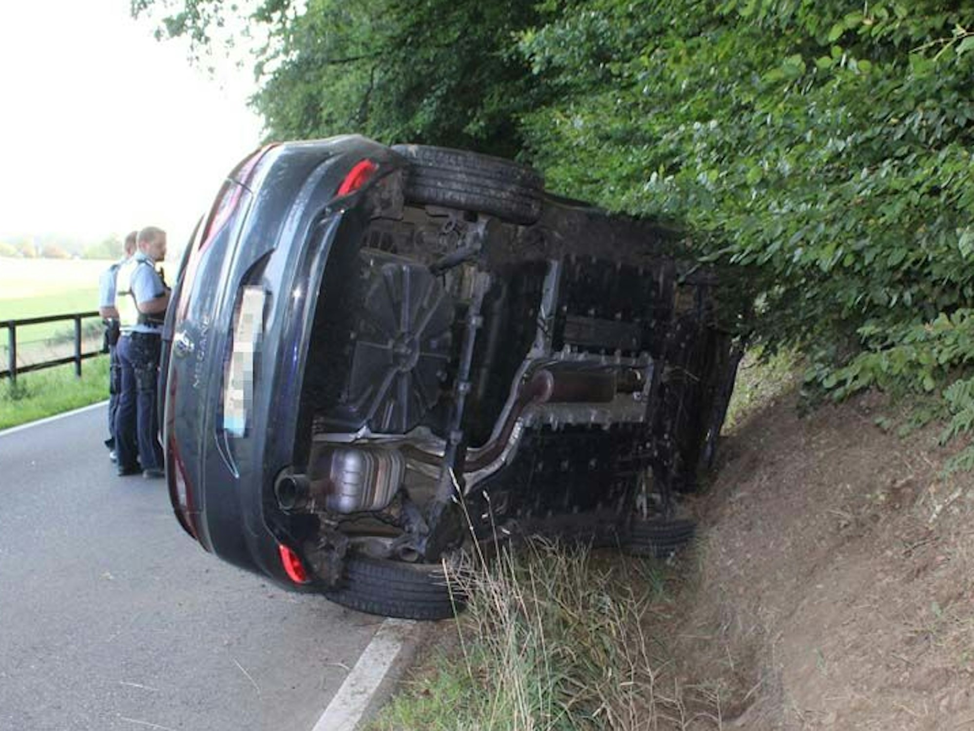 Ein überschlagener Pkw liegt in Kürten an einer Böschung.