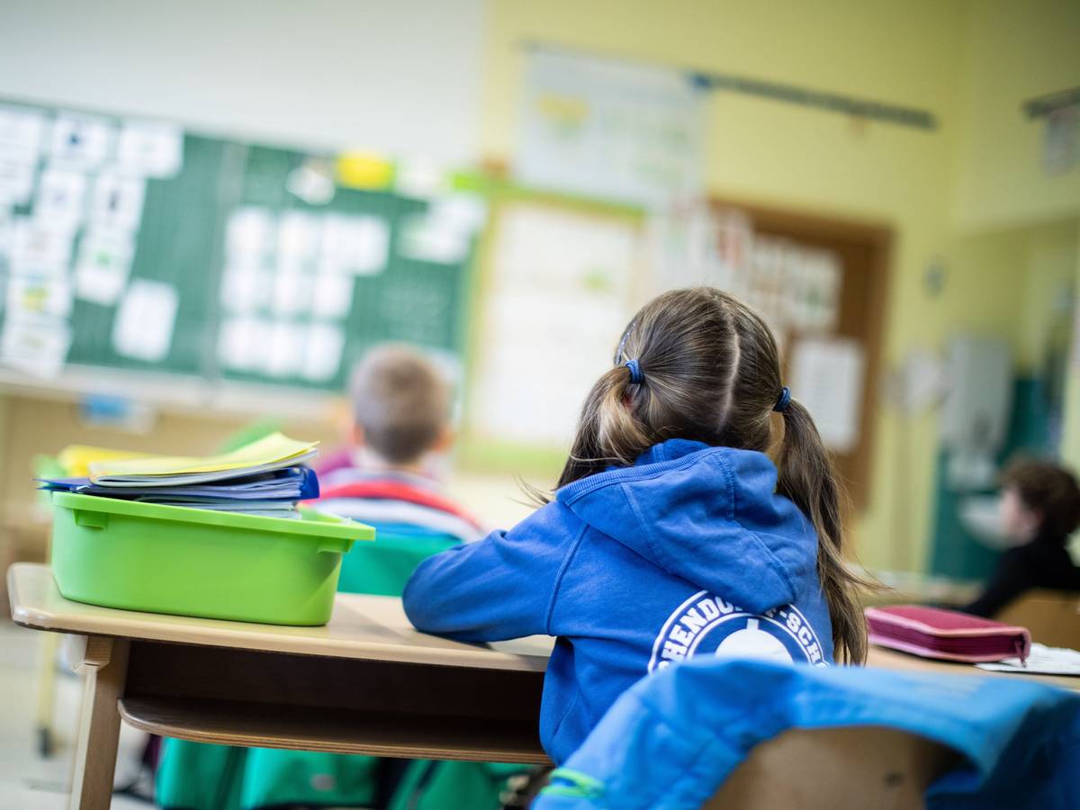 Schülerinnen und Schüler einer Grundschule sitzen mit Abstand in ihrem Klassenraum.