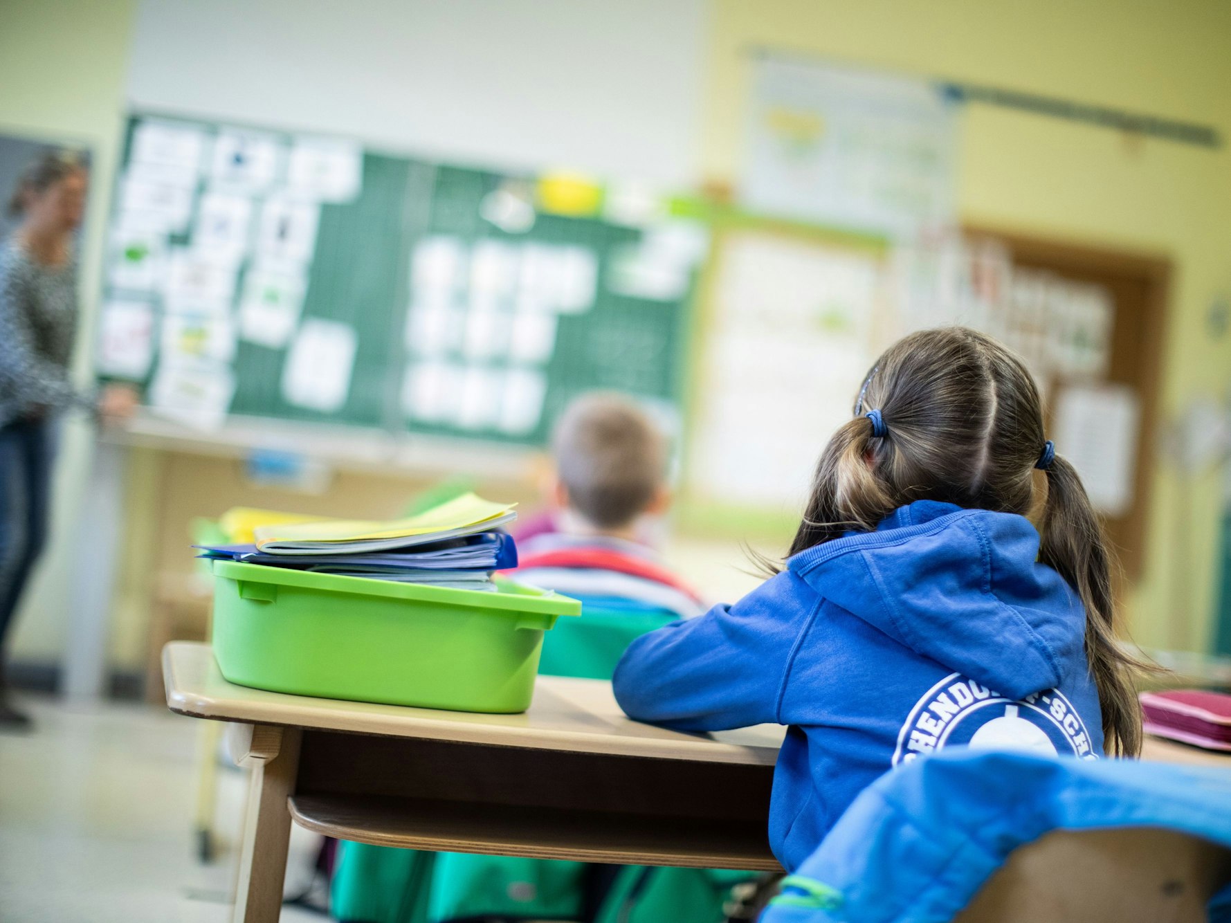 Schülerinnen und Schüler einer Grundschule sitzen mit Abstand in ihrem Klassenraum.
