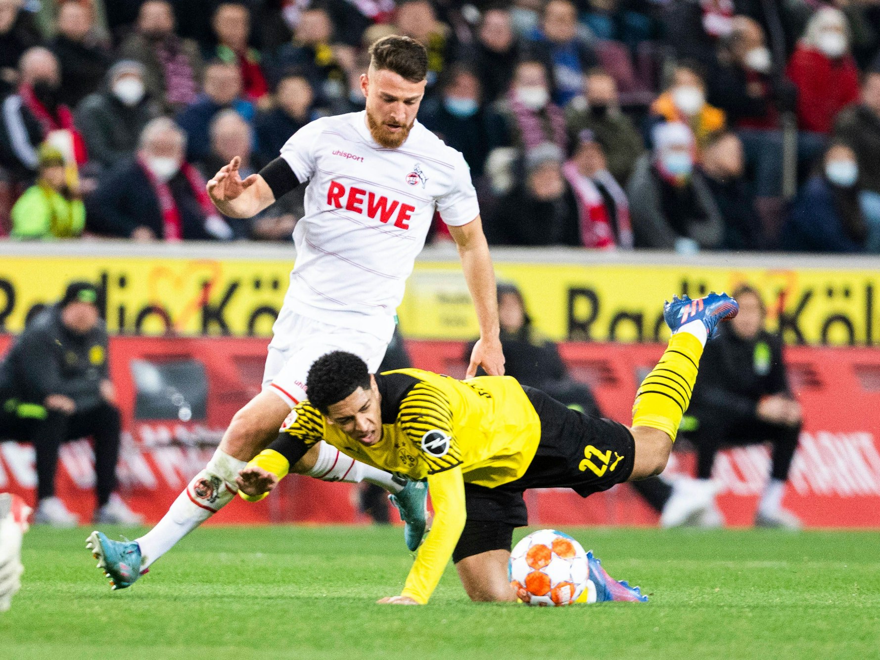 Der Ex-Kölner Salih Özcan im Duell mit seinem jetzigen Dortmunder Mitspieler Jude Bellingham am 20. März 2022 in Rhein-Energie-Stadion.