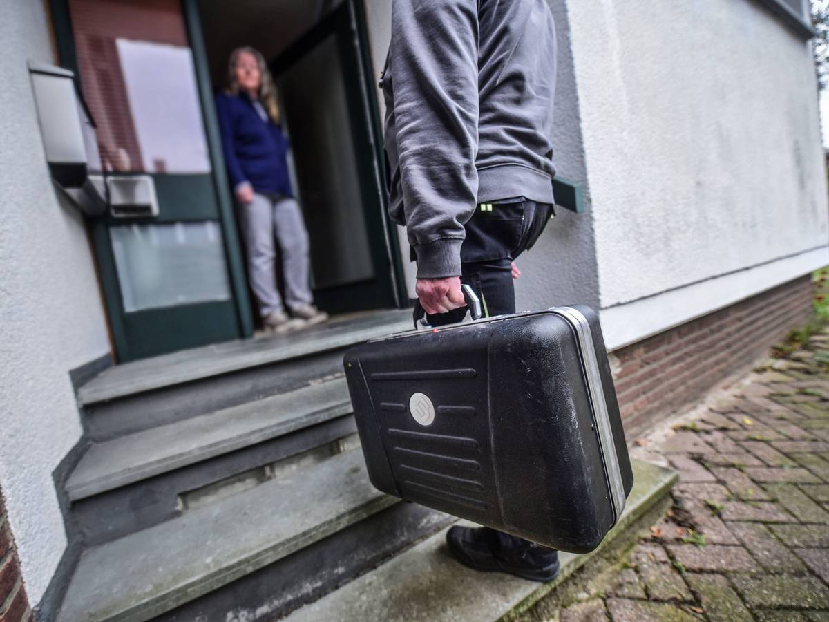 Ein Mann mit Handwerker-Koffer steht vor der geöffneten Haustür einer Frau.