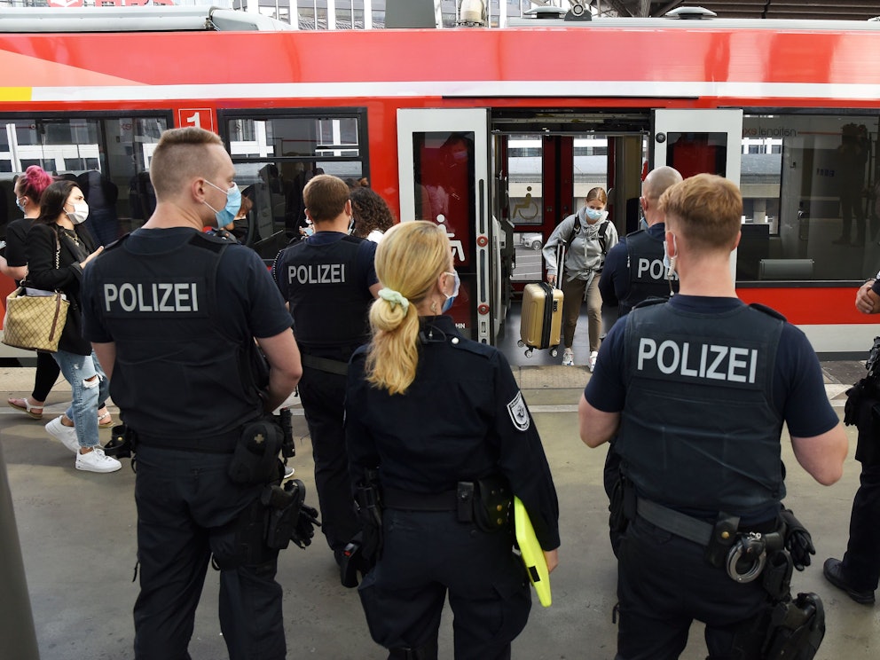 Beamte und Beamtinnen der Polizei und des Ordnungsamtes stehen im Kölner Hauptbahnhof.