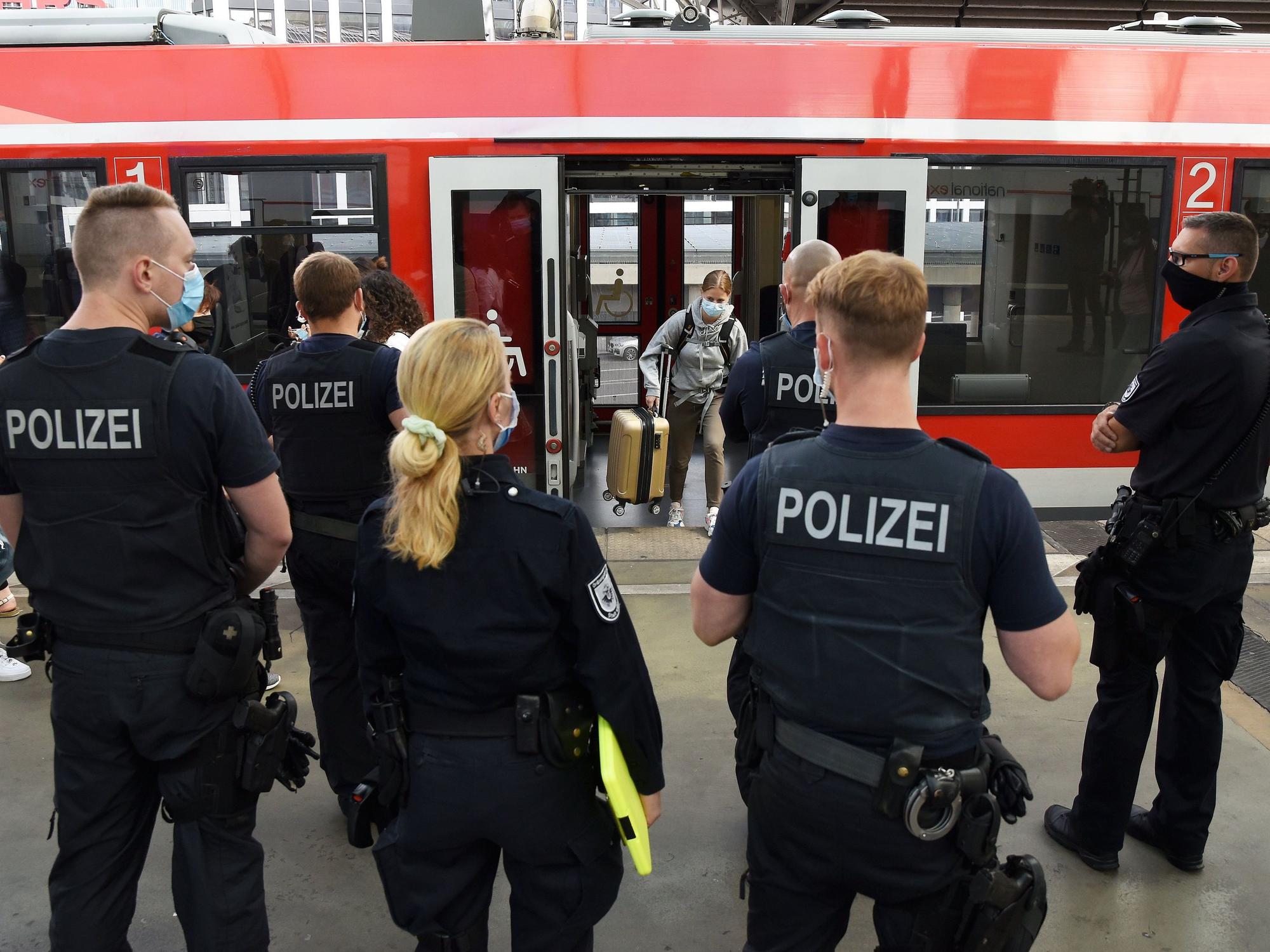 Beamte und Beamtinnen der Polizei und des Ordnungsamtes stehen im Kölner Hauptbahnhof.