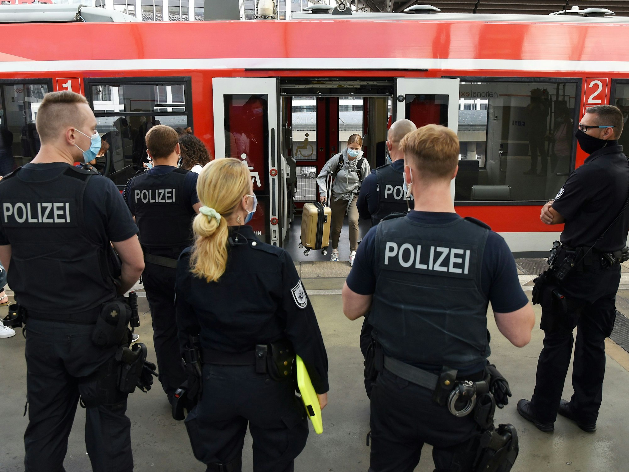 Beamte und Beamtinnen der Polizei und des Ordnungsamtes stehen im Kölner Hauptbahnhof.