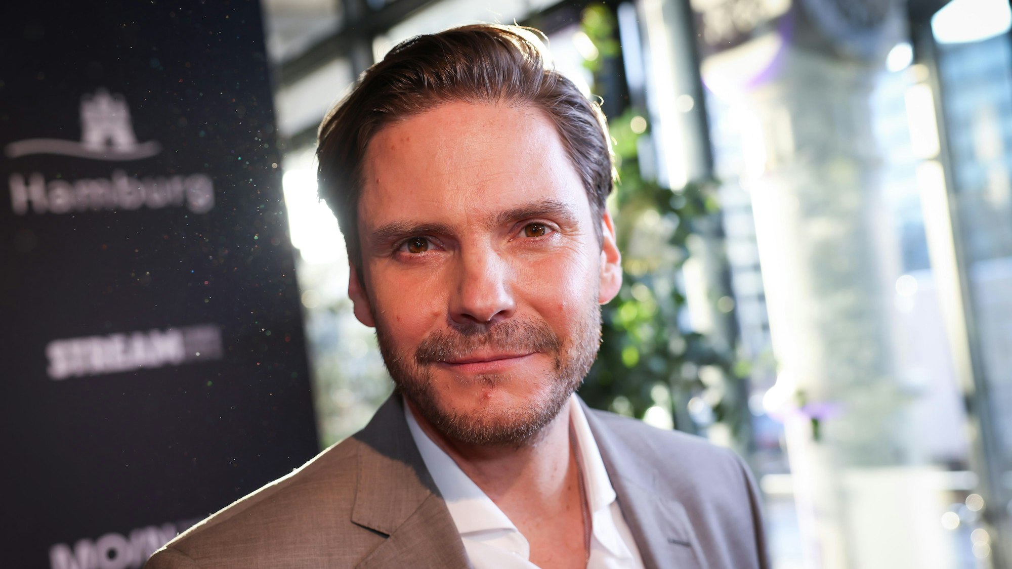 Schauspieler Daniel Brühl, hier am 27. April 2022 in Hamburg, lächelt in die Kamera.