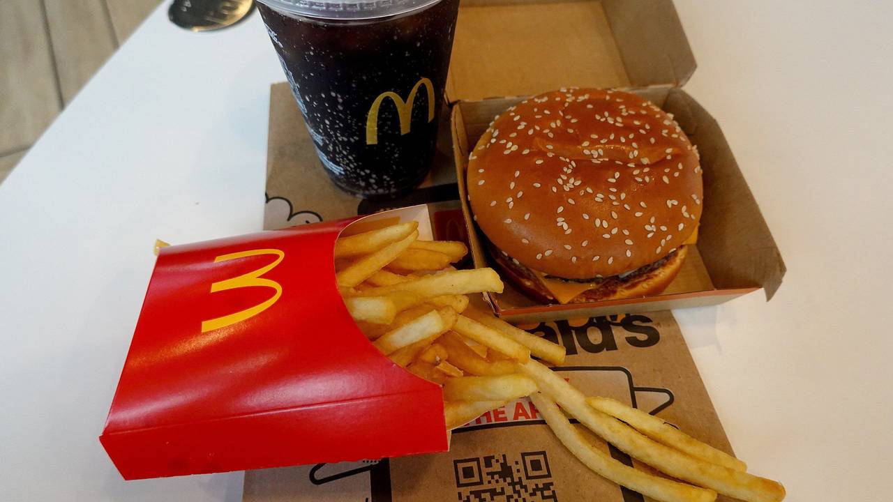 Ein Burger, eine Pommes und ein Getränk von McDonald's auf einem Tisch.