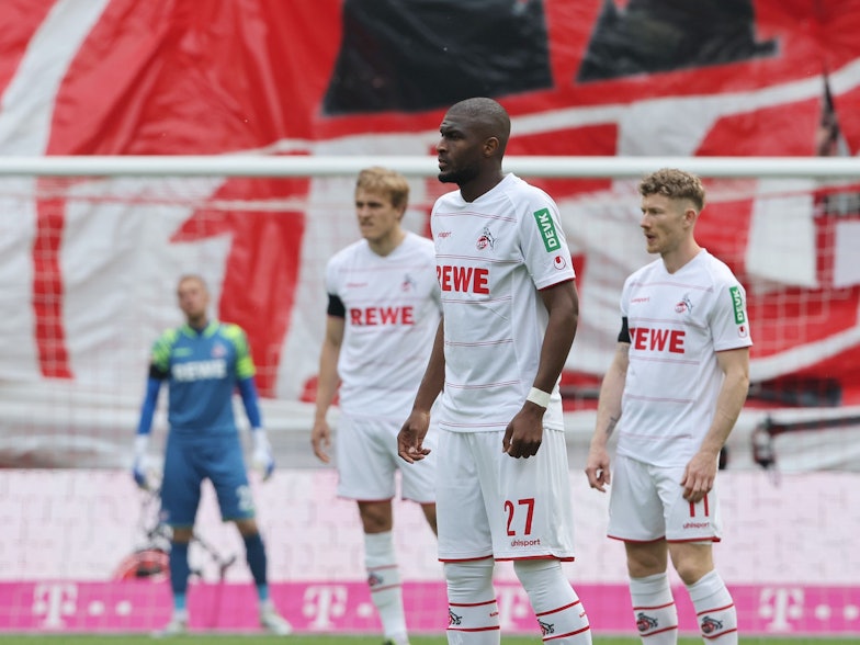 Anthony Modeste, Timo Hübers und Florian Kainz stehen im Spiel gegen den VfL Wolfsburg, als der 1. FC Köln die Teilnahme zur Conference League perfekt machte, auf dem Rasen