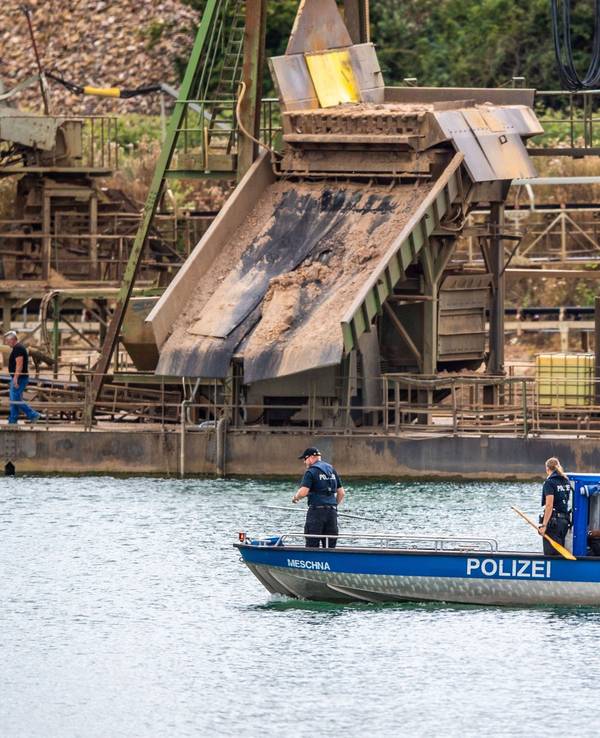 Die Polizei sucht auf einem Boot an einem Baggersee in Porta Westfalica nach einem vermissten Pärchen.