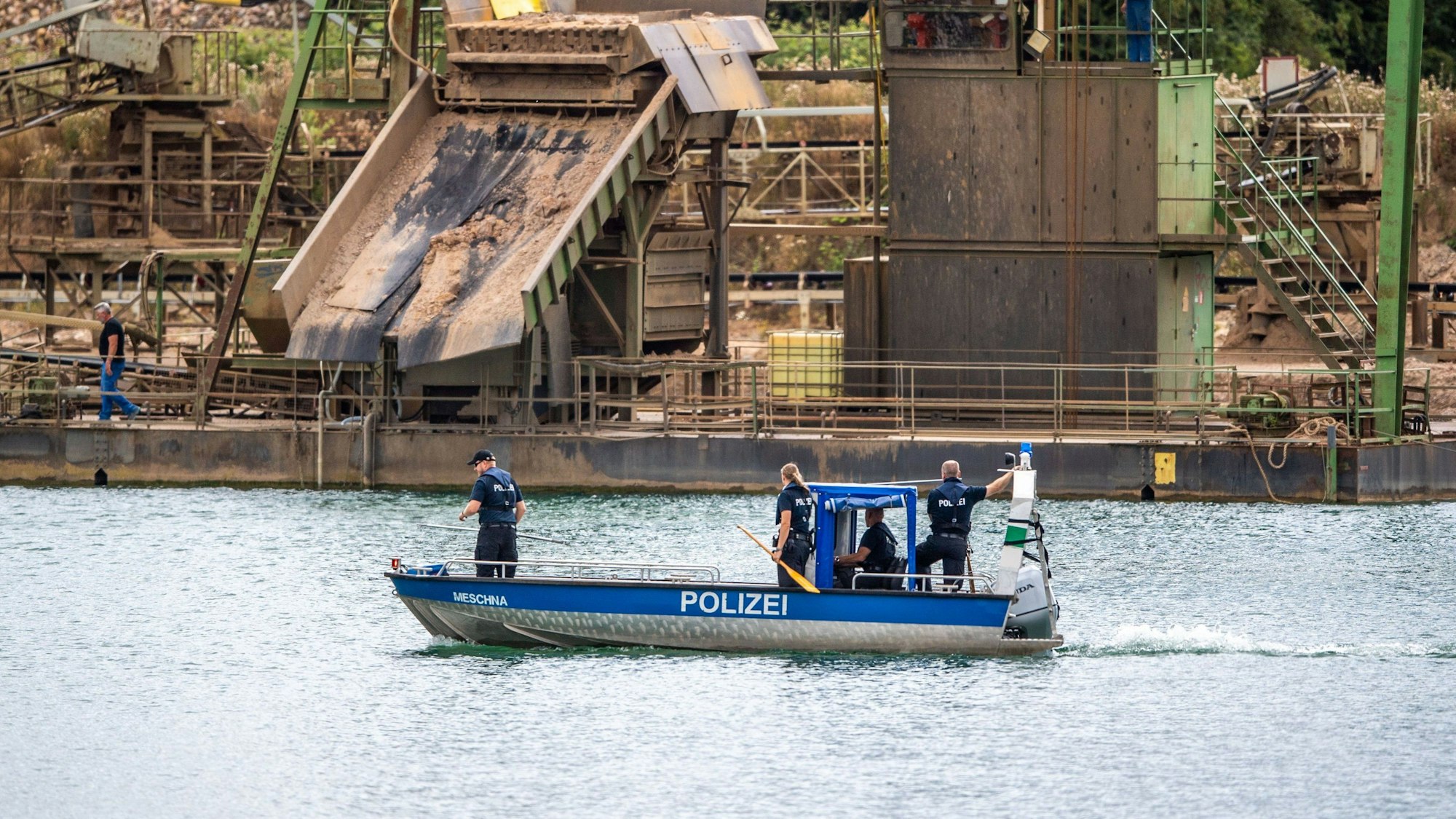 Die Polizei sucht auf einem Boot an einem Baggersee in Porta Westfalica nach einem vermissten Pärchen.