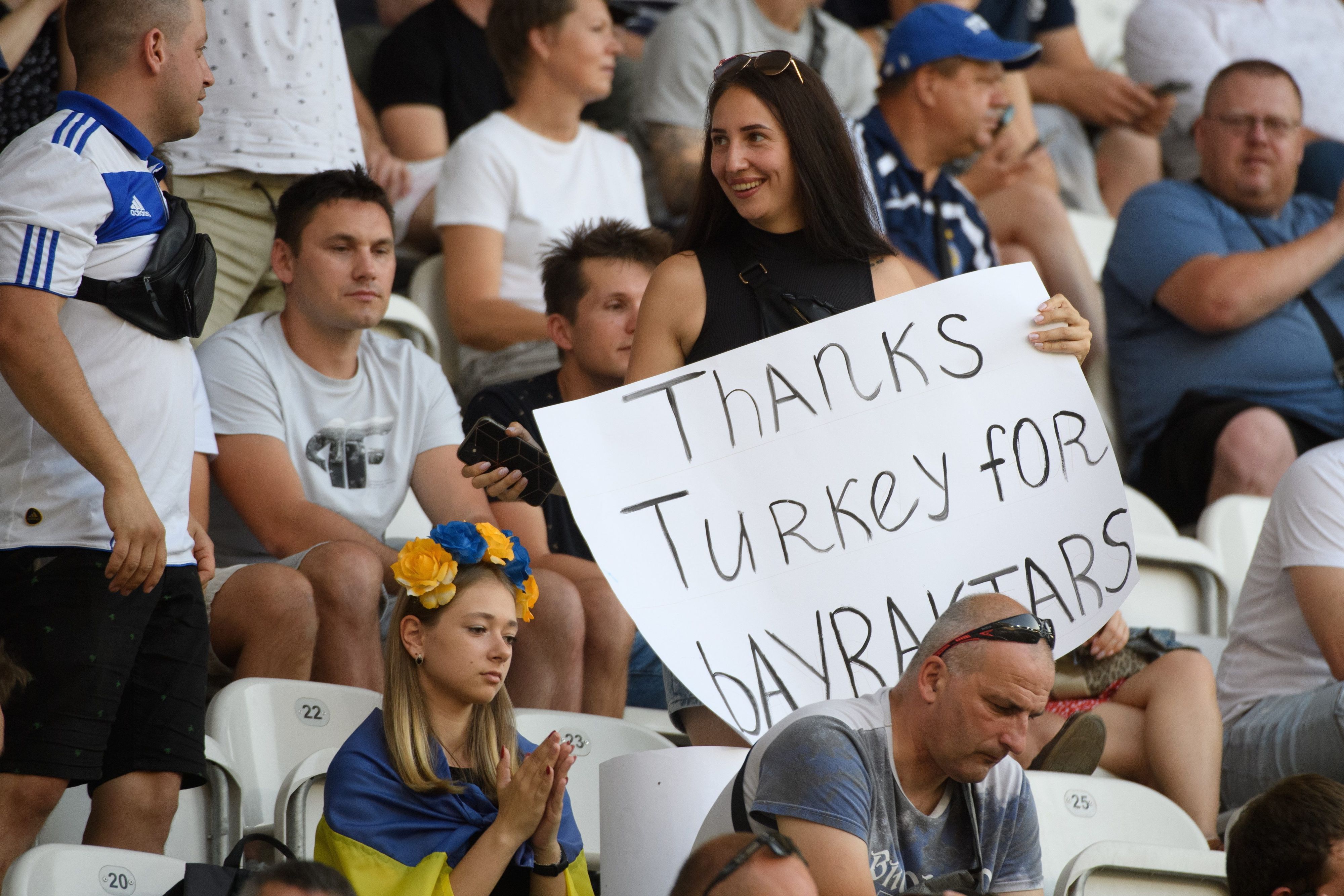 Ukrainische Fans jubeln. Eine Frau hält ein Schild "Thanks Turkey for the Bayraktars". 

Die Ukraine setzt im Kampf gegen die russischen Angreifer türkische Bayraktar-Drohnen ein.