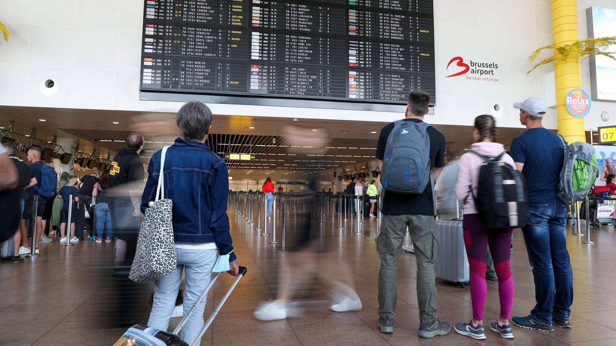 Reisende schauen in der Abflughalle des Brüsseler Flughafens in Zaventem auf die Anzeigetafel für den Abflug.