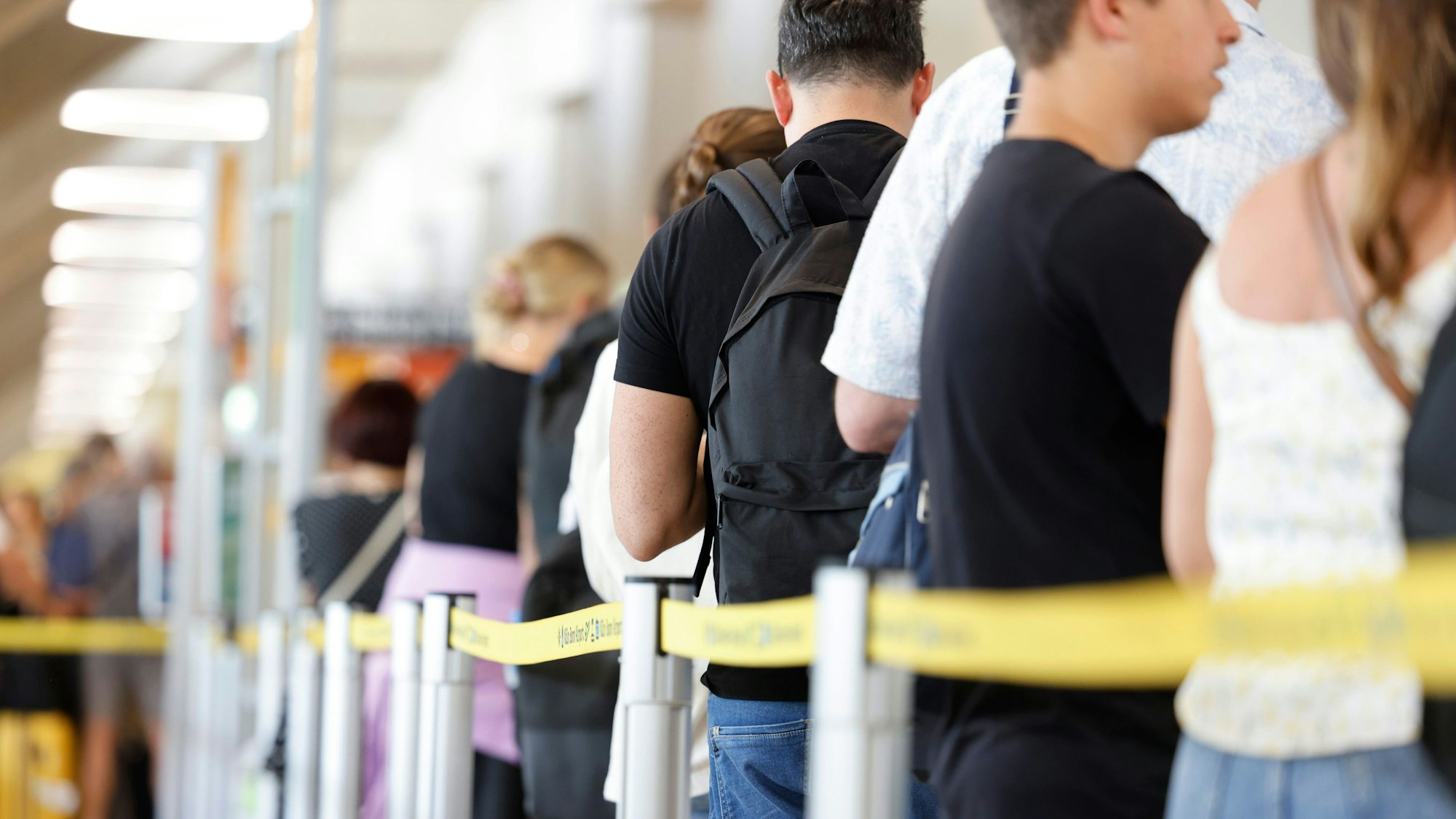 Menschen stehen am Flughafen Köln/Bonn in der Schlange.