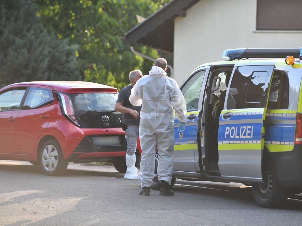 Einsatzkräfte der Polizei und Spurensicherung stehen vor einem Haus. Im Streit um eine Mietwohnung sind am Freitag im saarländischen Ottweiler zwei Menschen getötet und ein Mann verletzt worden.