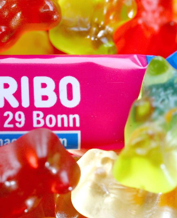 Die Nahaufnahme zeigt eine Tüte „Maoam“ mit dem Schriftzug „D-53129 Bonn“ und viele Gummibärchen der Firma Haribo.