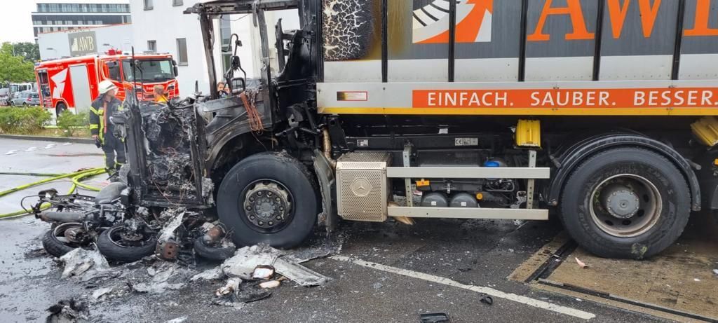 Der vordere Bereich eines Müllwagens ist ausgebrannt.