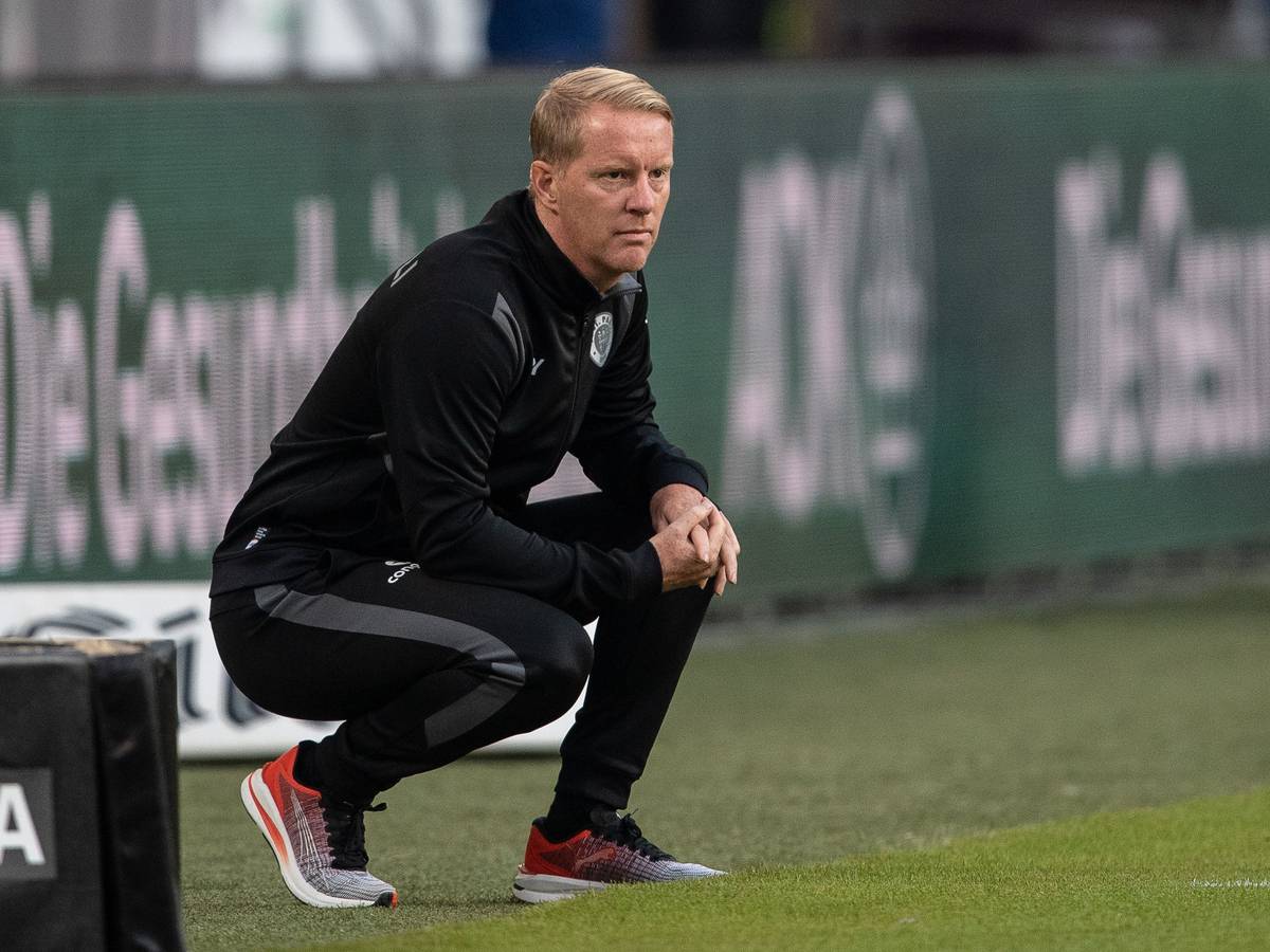 Timo Schultz geht bei einem Spiel des FC St. Pauli in seiner Coachingzone in die Hocke.