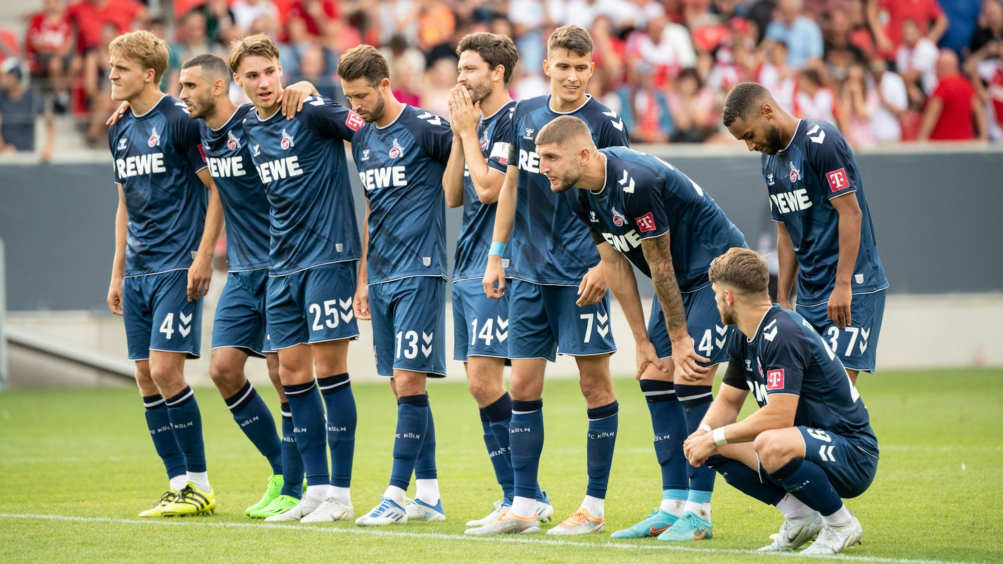 Die Spieler vom 1. FC Köln verfolgen das Elfmeterschießen.