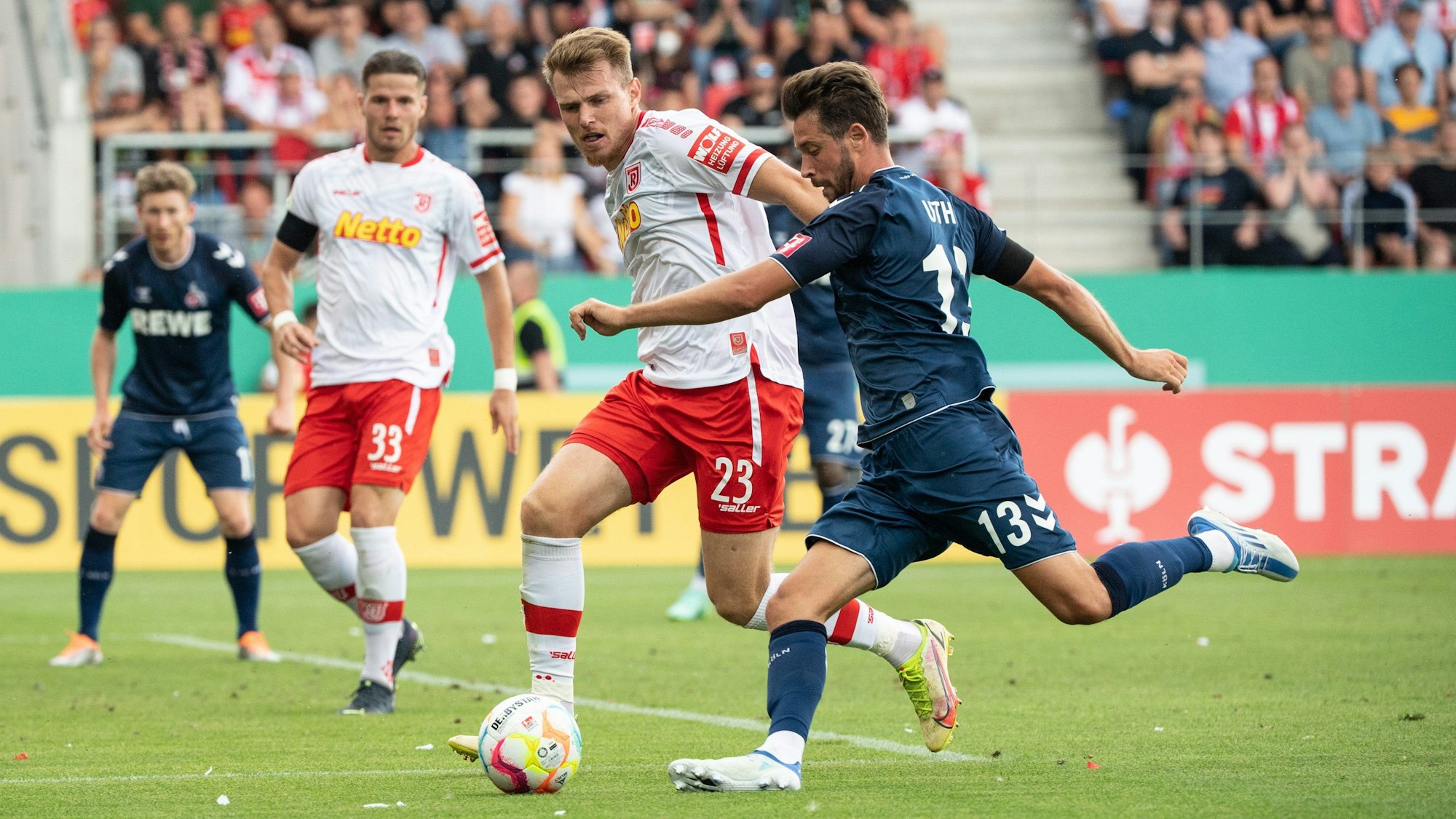 Steve Breitkreuz vom SSV Jahn Regensburg (l) und Mark Uth vom 1. FC Köln im Zweikampf um den Ball.