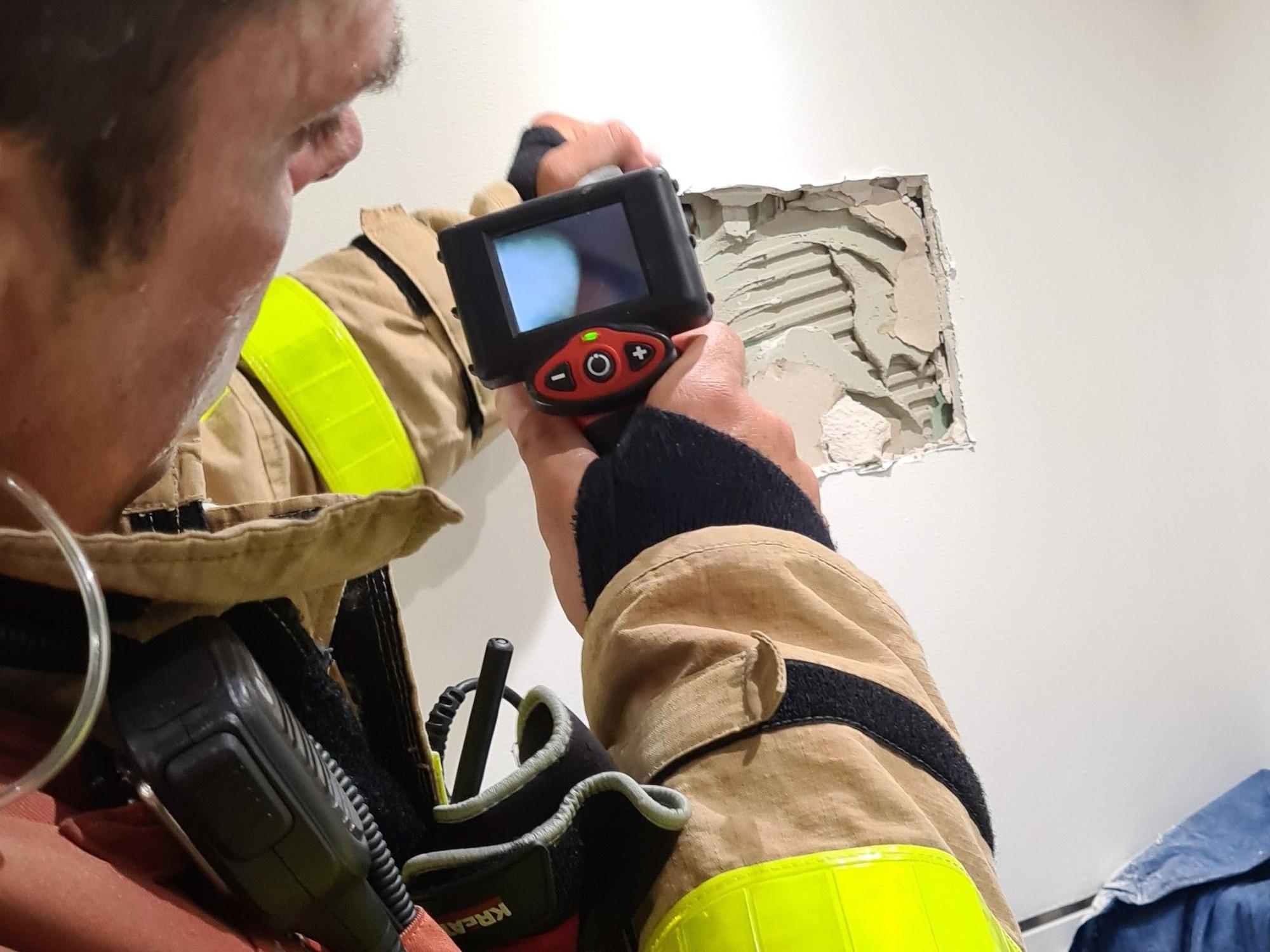 Mithilfe einer Endoskopkamera suchen Einsatzkräfte der Feuerwehr Grevenbroich keine kleine Katze, die vom Dachboden in die Tiefe gestürzt war.