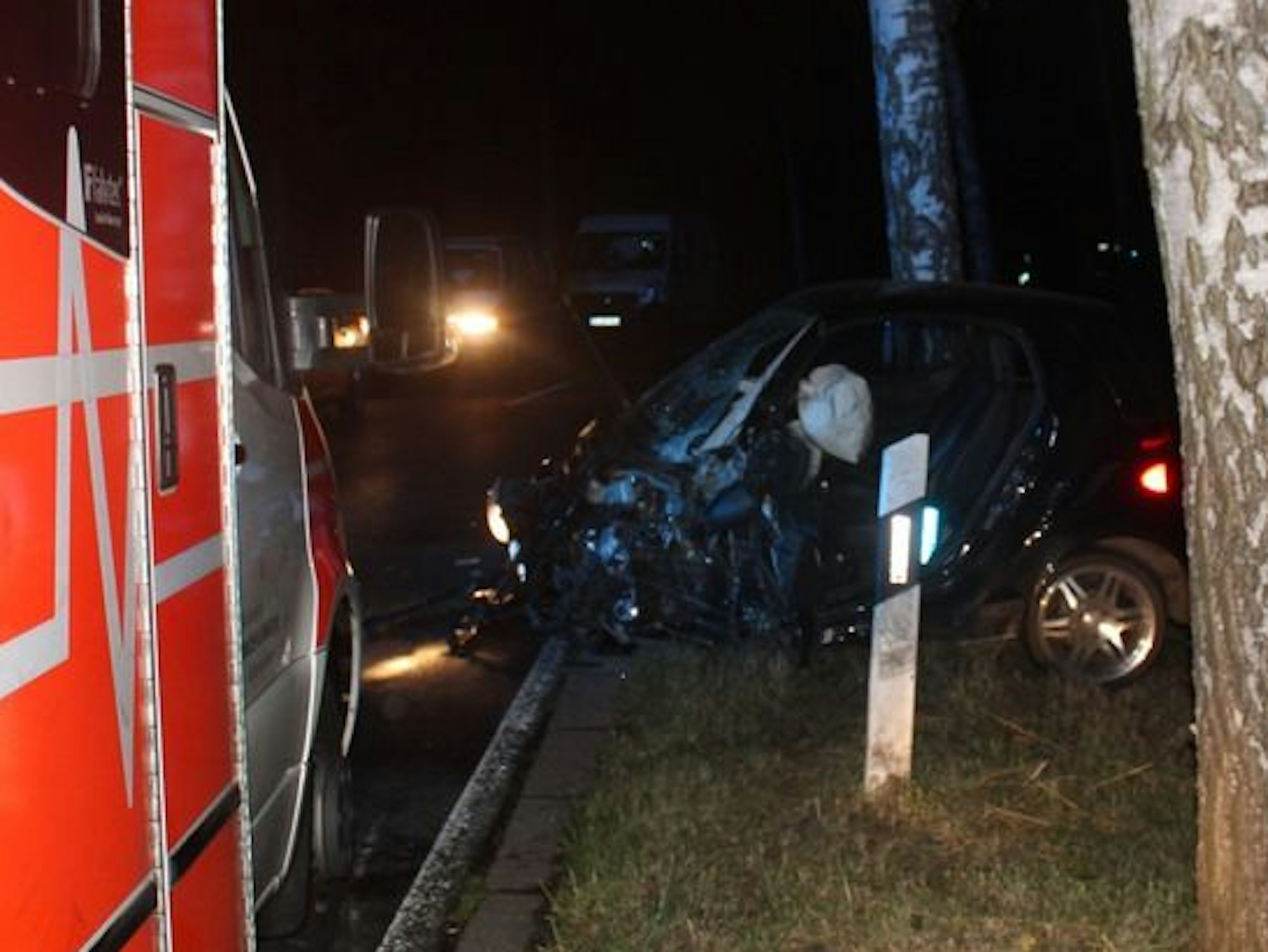 Ein zerstörter Smart steht am Straßenrand.